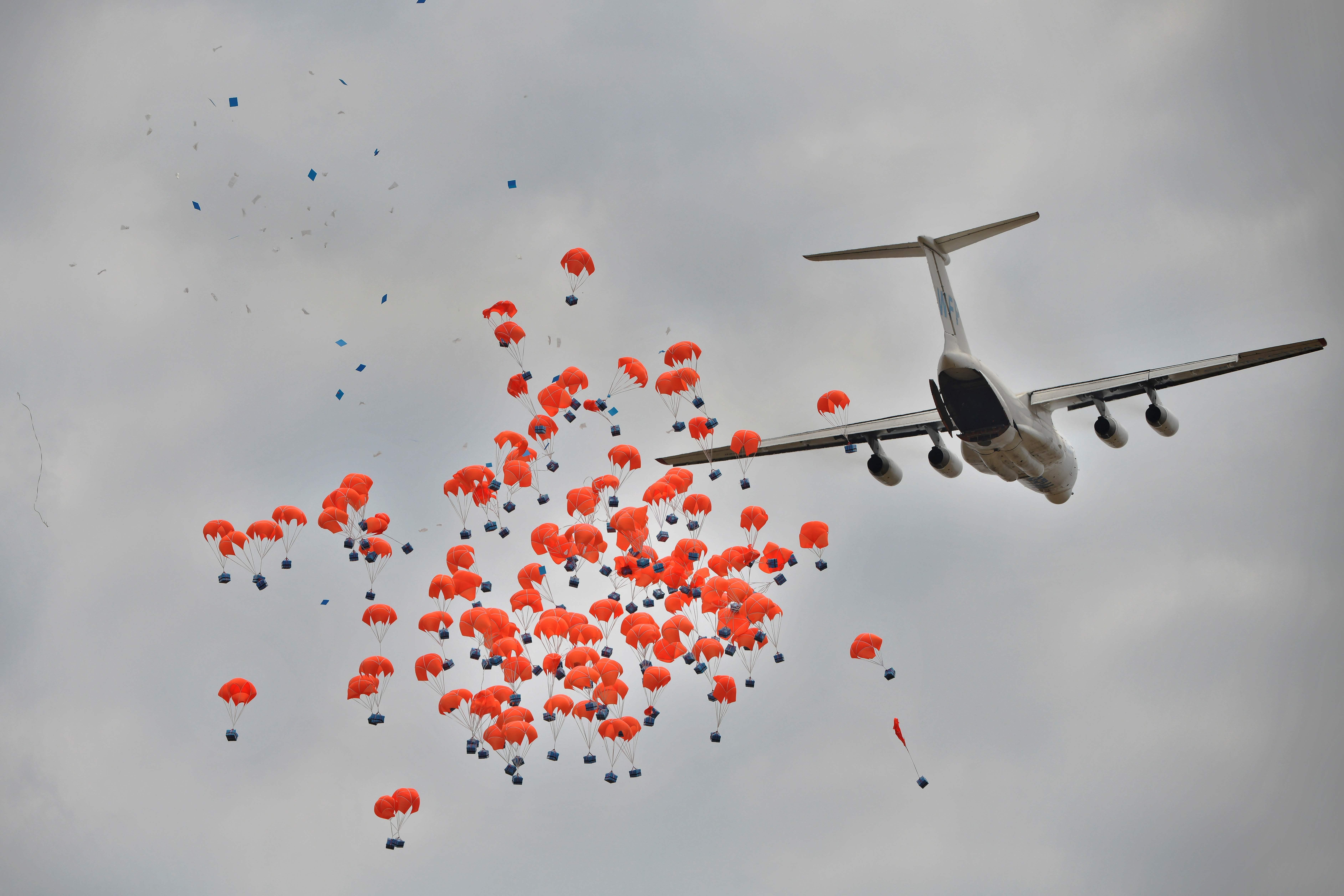 (FILES) In this file photo taken on February 06, 2020 A Russian-made Ilyushin airlifter aircraft leased to the World Food Programme (WFP) makes a drop of food aid near a village in Ayod county, South Sudan. The World Food Progamme (WPF) wins the 2020 Nobel Peace Prize, the Norwegian Nobel Committee has has announced on October 09, 2020. (Photo by TONY KARUMBA / AFP)