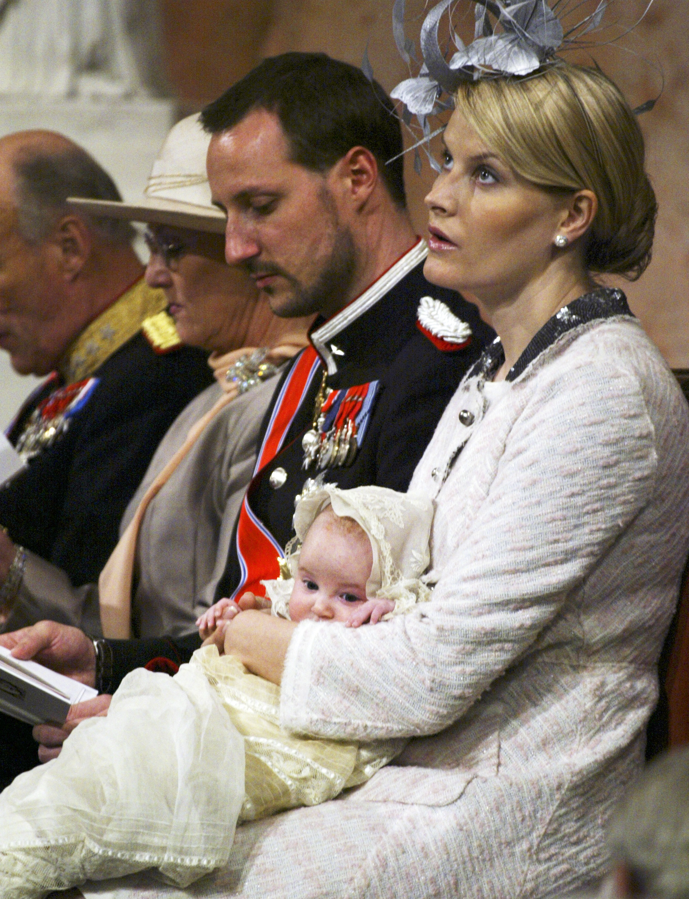 Slottskapellet. Kronprinsesse Mette-Marit, med dåpsbarnet, prinsesse Ingrid Alexandra, under dåpsseremonien i Slottskapellet lørdag.  Prinsessen ble døpt i samme kjole som kong Olav ble døpt i på Sandringham slott 11. august 1903. Ved siden av henne sitter f.h. kronprins Haakon, Dronning Sonja og helt t.v. delvis ute av bilde kong Harald.