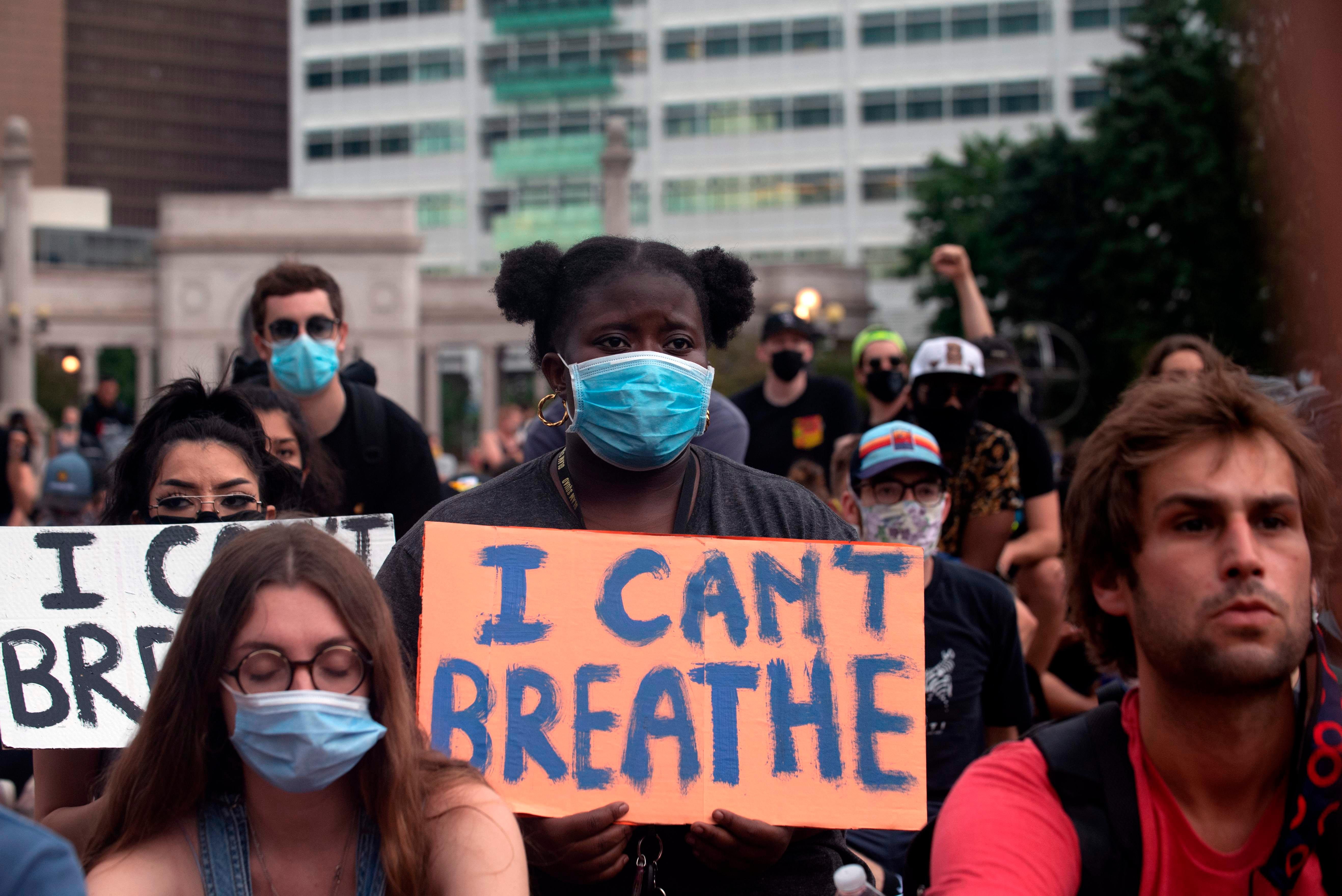 A demonstrator holds a sign in Denver, Colorado on June 3, 2020, while protesting the death of George Floyd, an unarmed black man who died while while being arrested and pinned to the ground by the knee of a Minneapolis police officer. - US protesters welcomed new charges brought Wednesday against Minneapolis officers in the killing of African American man George Floyd -- but thousands still marched in cities across the country for a ninth straight night, chanting against racism and police brutality. (Photo by Jason Connolly / AFP)