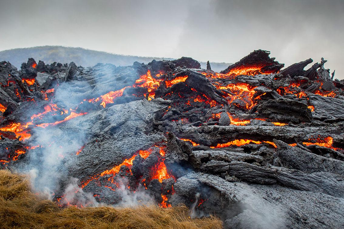 Bildet viser rødglødende lava som strømmer ut av vulkanen Fagradalsfjall på Island.
