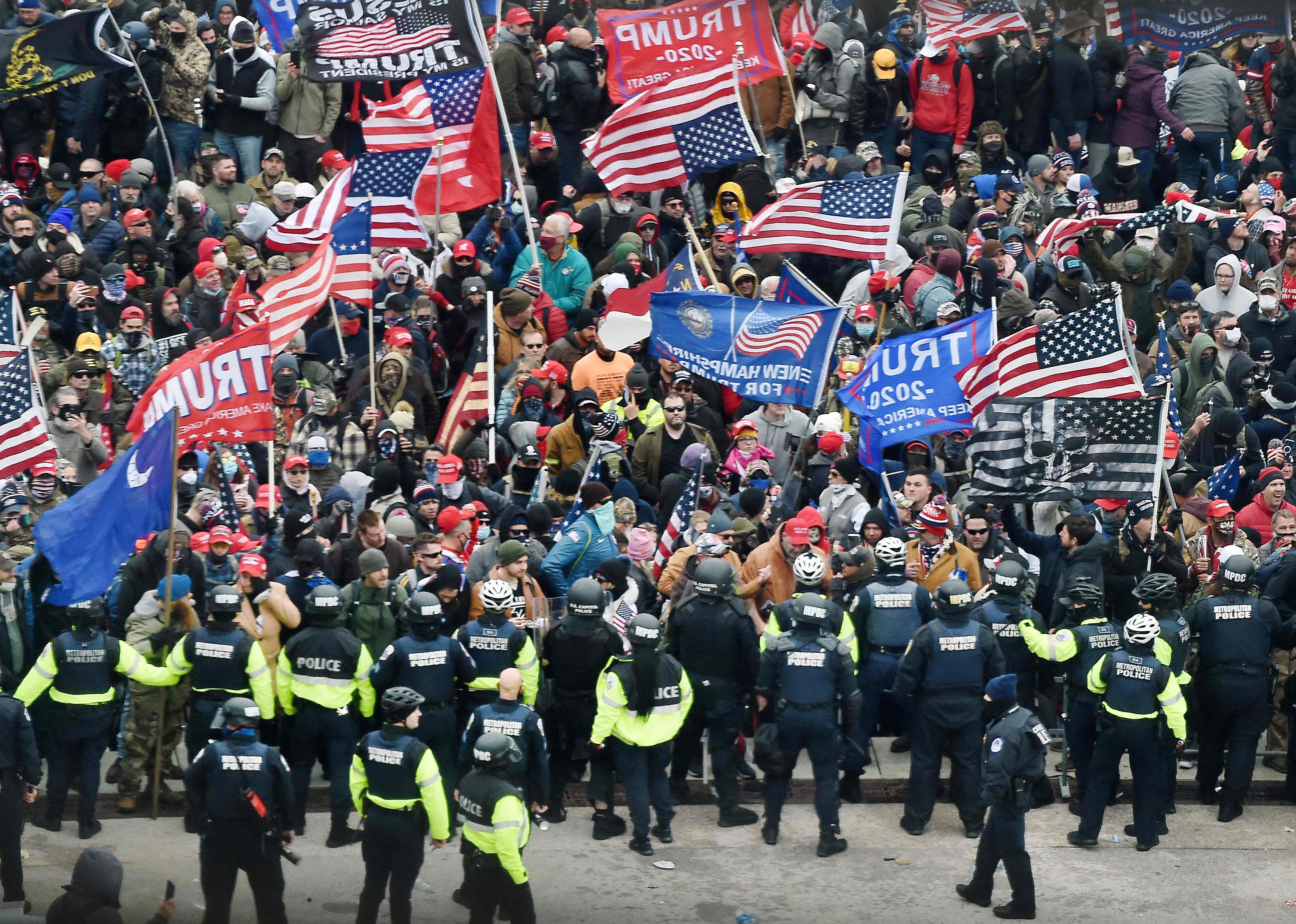 Trump supporters clash with police and security forces as they storm the US Capitol in Washington, DC on January 6, 2021. - Donald Trump's supporters stormed a session of Congress held today, January 6, to certify Joe Biden's election win, triggering unprecedented chaos and violence at the heart of American democracy and accusations the president was attempting a coup. (Photo by Olivier DOULIERY / AFP)