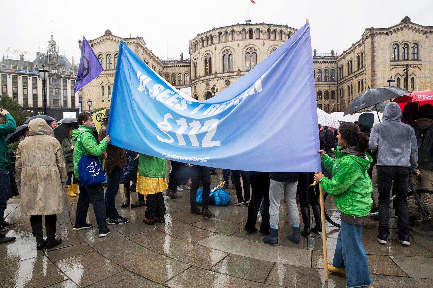 Bildet viser demonstranter med et stort banner.