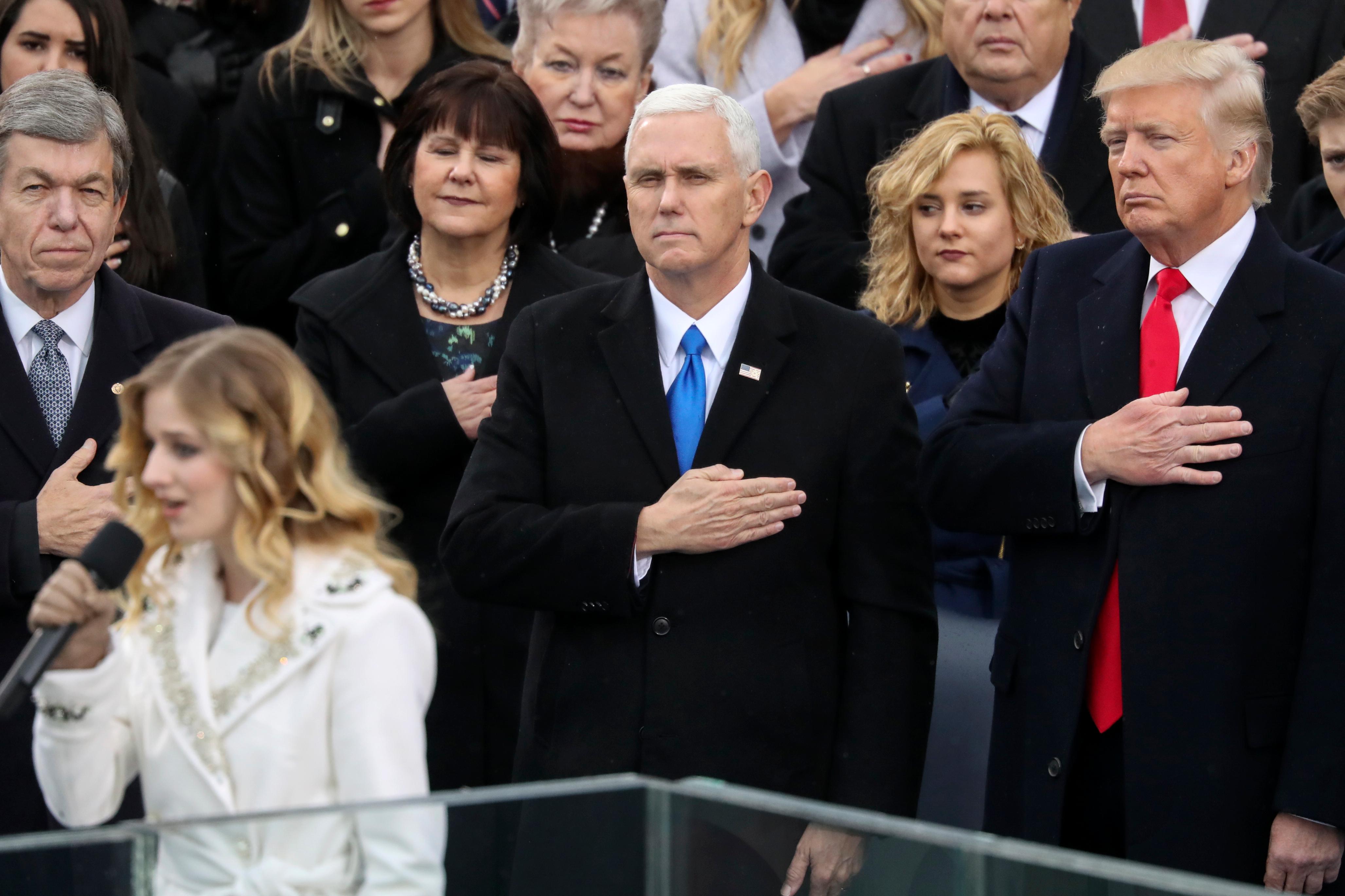 FILE - In this Jan. 20, 2017, file photo, Vice President Mike Pence and President Donald Trump listen to the singing of the national anthem by Jackie Evancho during the 58th Presidential Inauguration at the U.S. Capitol in Washington. Evancho asked Trump in a tweet on Feb. 22, 2017,   to meet with her and her transgender sister on transgender rights. (AP Photo/Andrew Harnik, File)