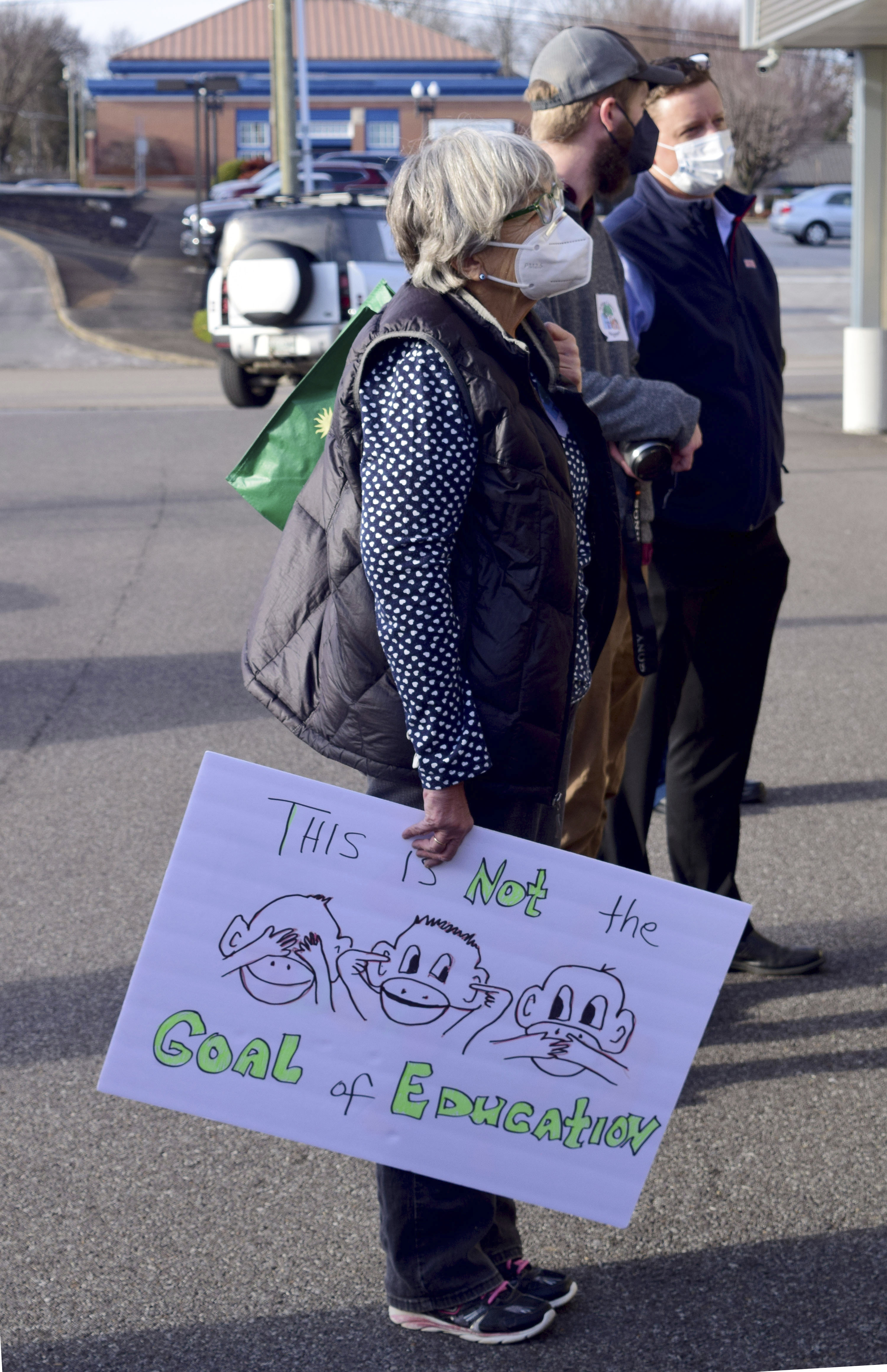 A woman carries a sign critical of the McMinn County School Board, Thursday, Feb. 10, 2022, in Athens, Tenn. The McMinn County school board heard from concerned citizens about the removal of Pulitzer Prize-winning graphic novel about the Holocaust "Maus," from the district's curriculum at the meeting. (Robin Rudd/Chattanooga Times Free Press via AP)