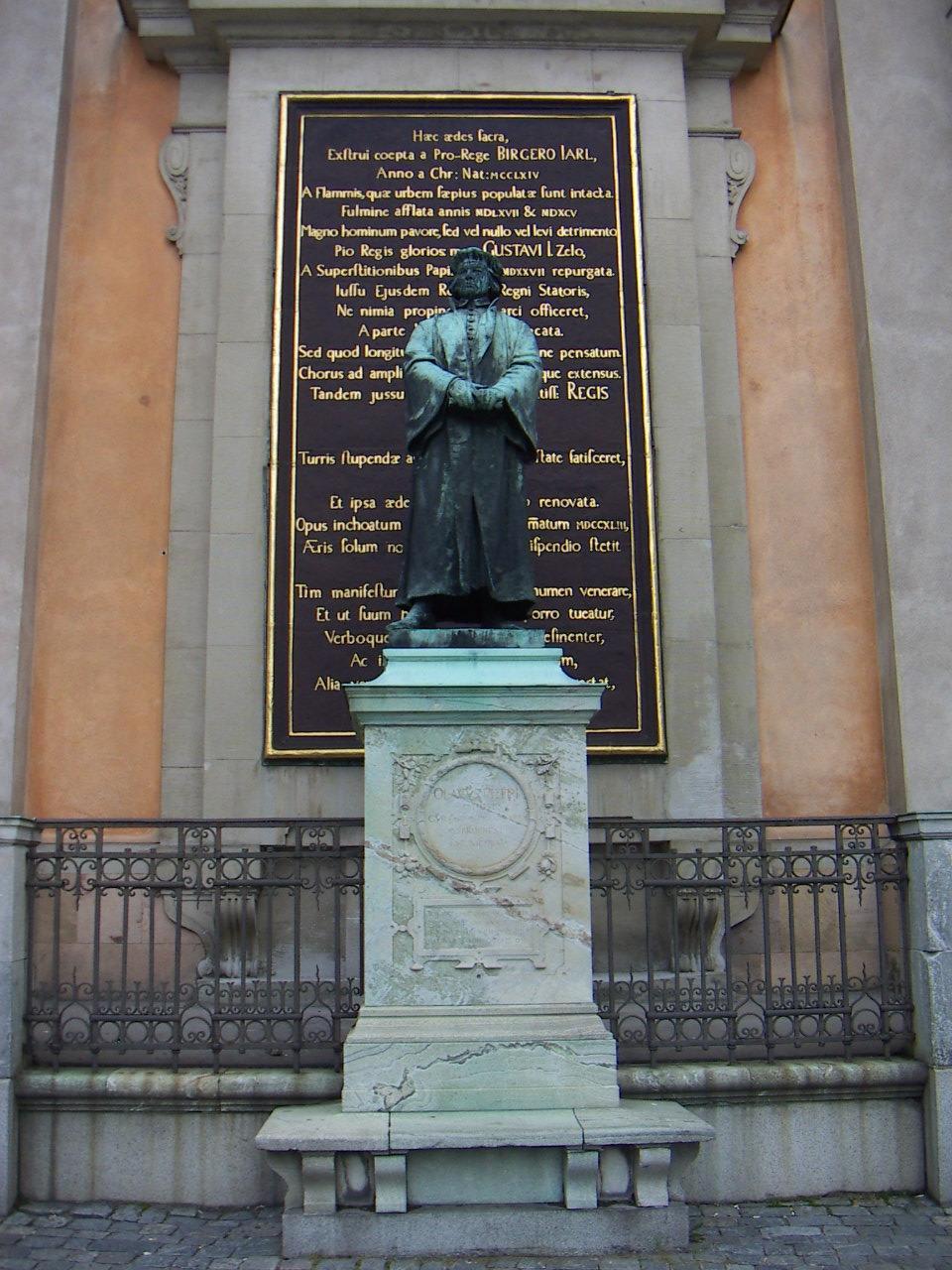 Olaus Petri står staty utanför Storkyrkan i Gamla stan i Stockholm.