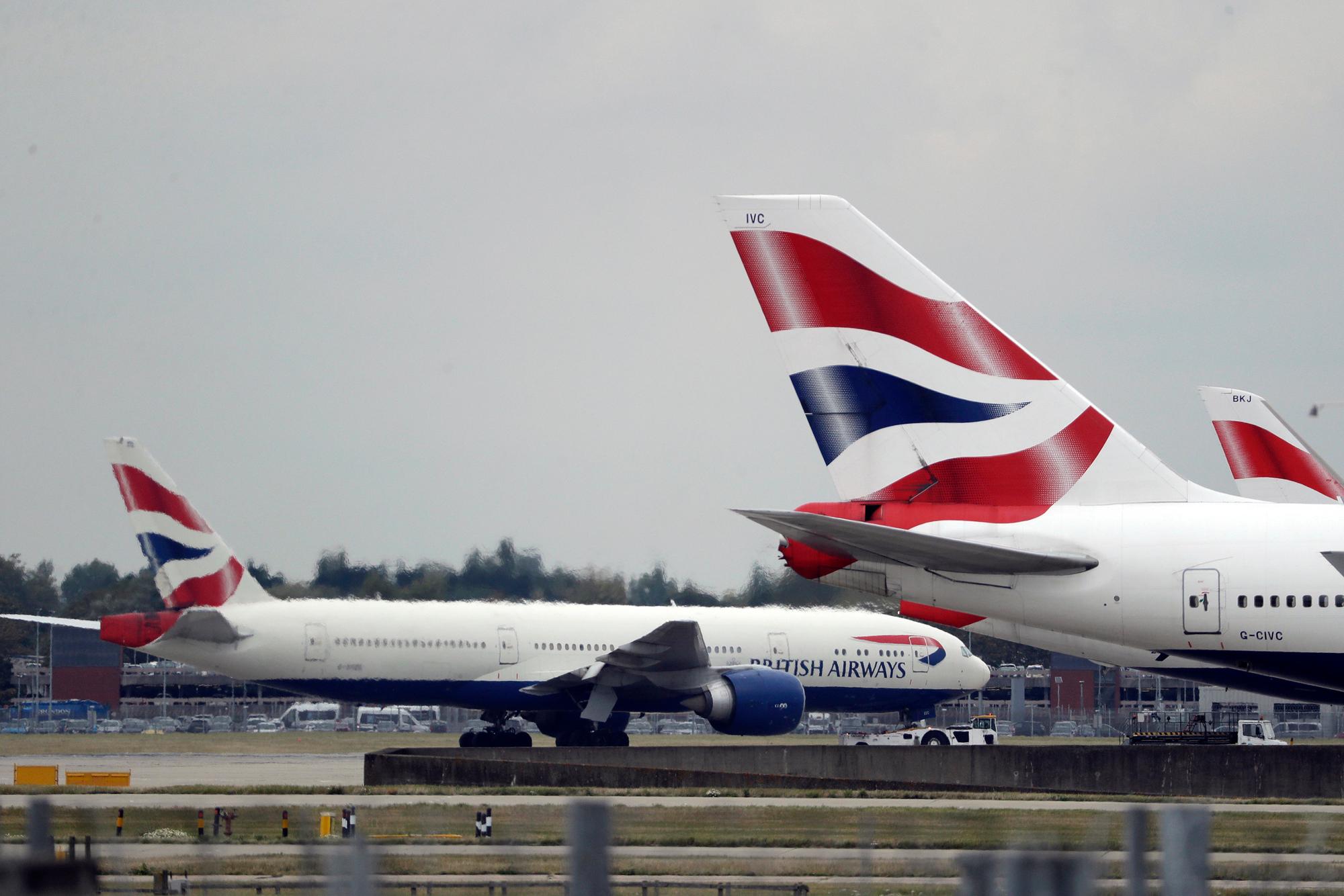 FILE - In this Sept. 9, 2019, file photo, a British Airways plane, left, is towed past other planes sitting parked at Heathrow Airport in London. The outbreak of the new virus threatens to erase $29 billion of this year's revenue for global airlines, mostly for Chinese carriers, as travel crashes worldwide, according to the International Air Transport Association. International airlines including British Airways, Germanys Lufthansa, Australias Qantas and the three largest U.S. airlines have suspended flights to China, in some cases until late April or May. (AP Photo/Matt Dunham, File)