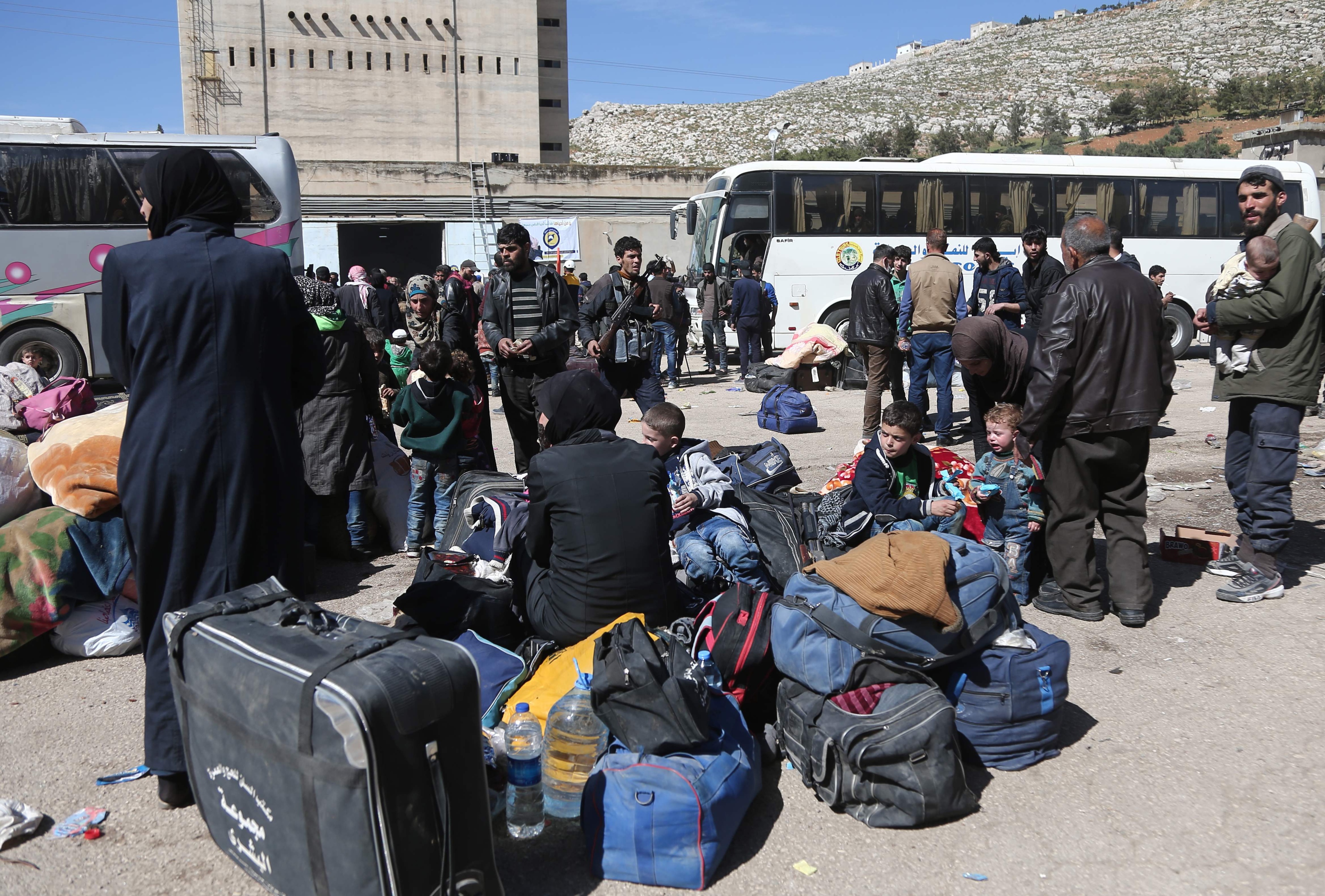 Bilet viser folk og busser i Øst-Ghouta i Syria. 