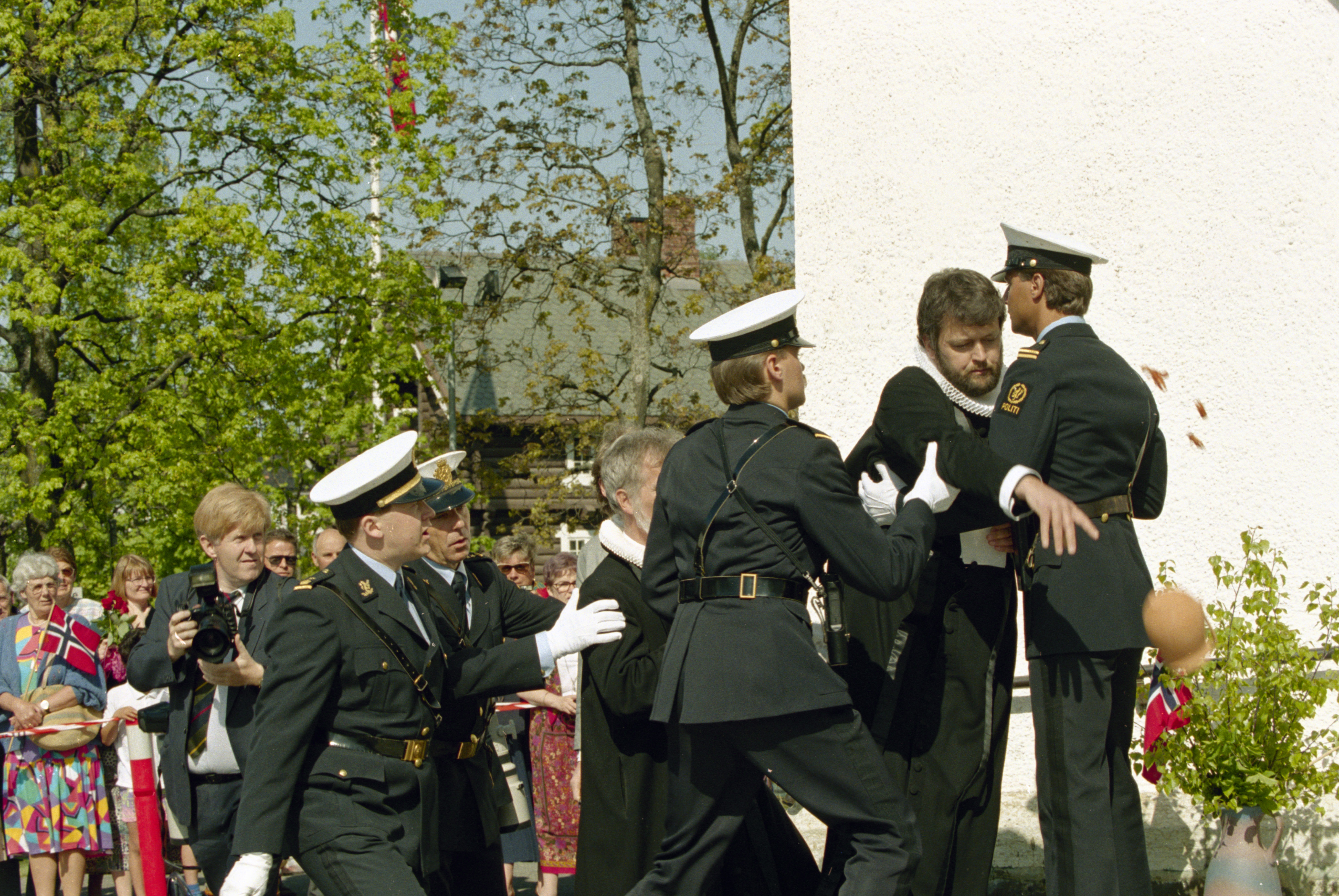 Hamar 19930520: Bispevigsling av Norges første kvinnelige biskop. Hamars nye biskop Rosemarie Köhn blir vigslet i Hamar Domkirke. Utenfor kirken benyttet anti-abortprestene Ludvig Nessa og Børre Knudsen (delvis skjult) anledningen til å foreta en demonstrasjon. Her blir de pågrepet og arrestert av politiet etter at de forstyrret orden med å kaste en krukke (til h.) mot inngangen til Domkirken rett før kongeparet ankom. FOTO: Bjørn Sigurdsøn