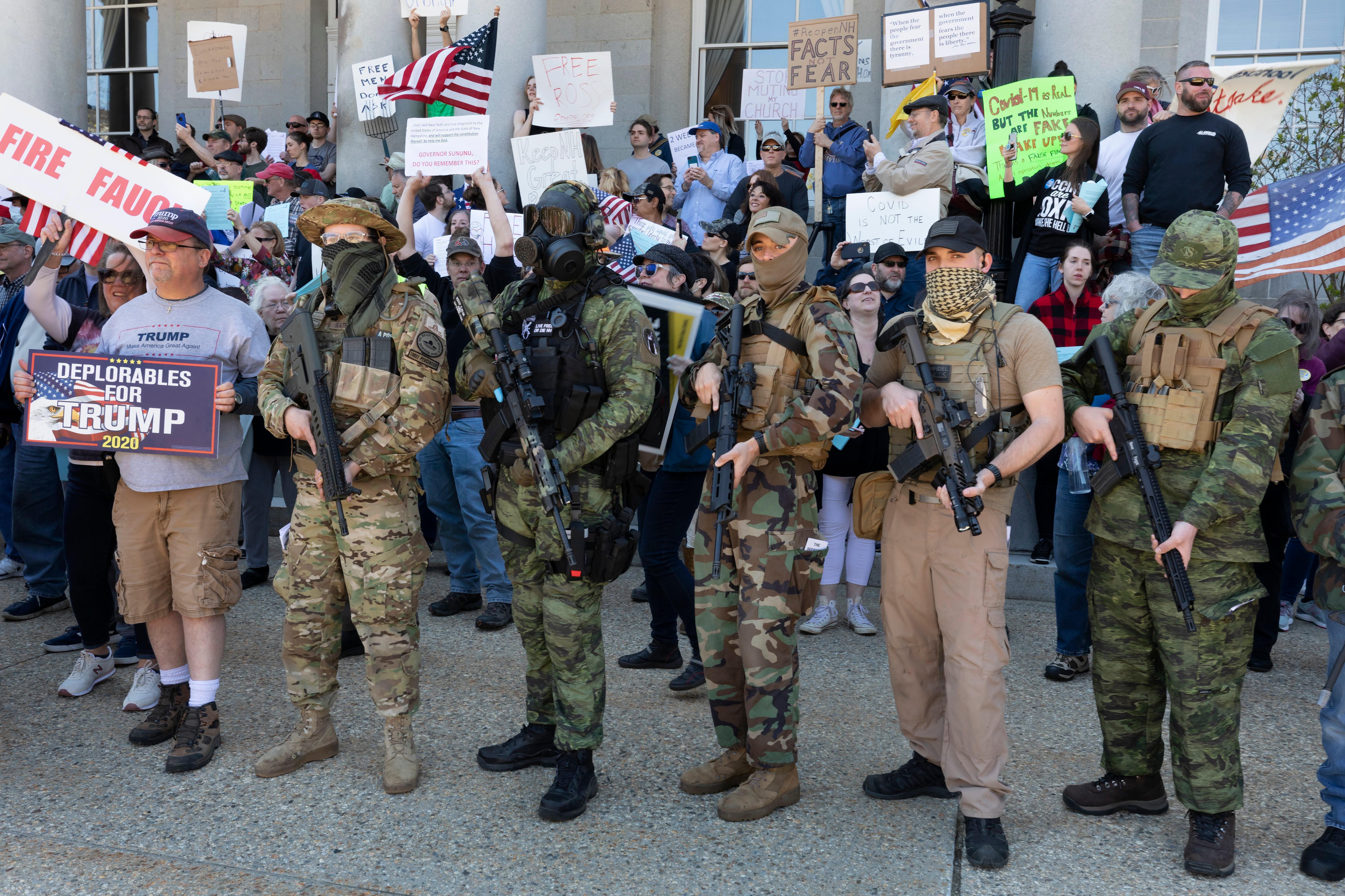 FILE - In this May 2, 2020, file photo, people, including those with the boogaloo movement, demonstrate against business closures due to concern about COVID-19, at the State House in Concord, N.H.  It's a fringe movement with roots in a online meme culture steeped in irony and dark humor. But experts warn that the anti-government boogaloo movement has attracted a dangerous element of far-right extremists. (AP Photo/Michael Dwyer, File)