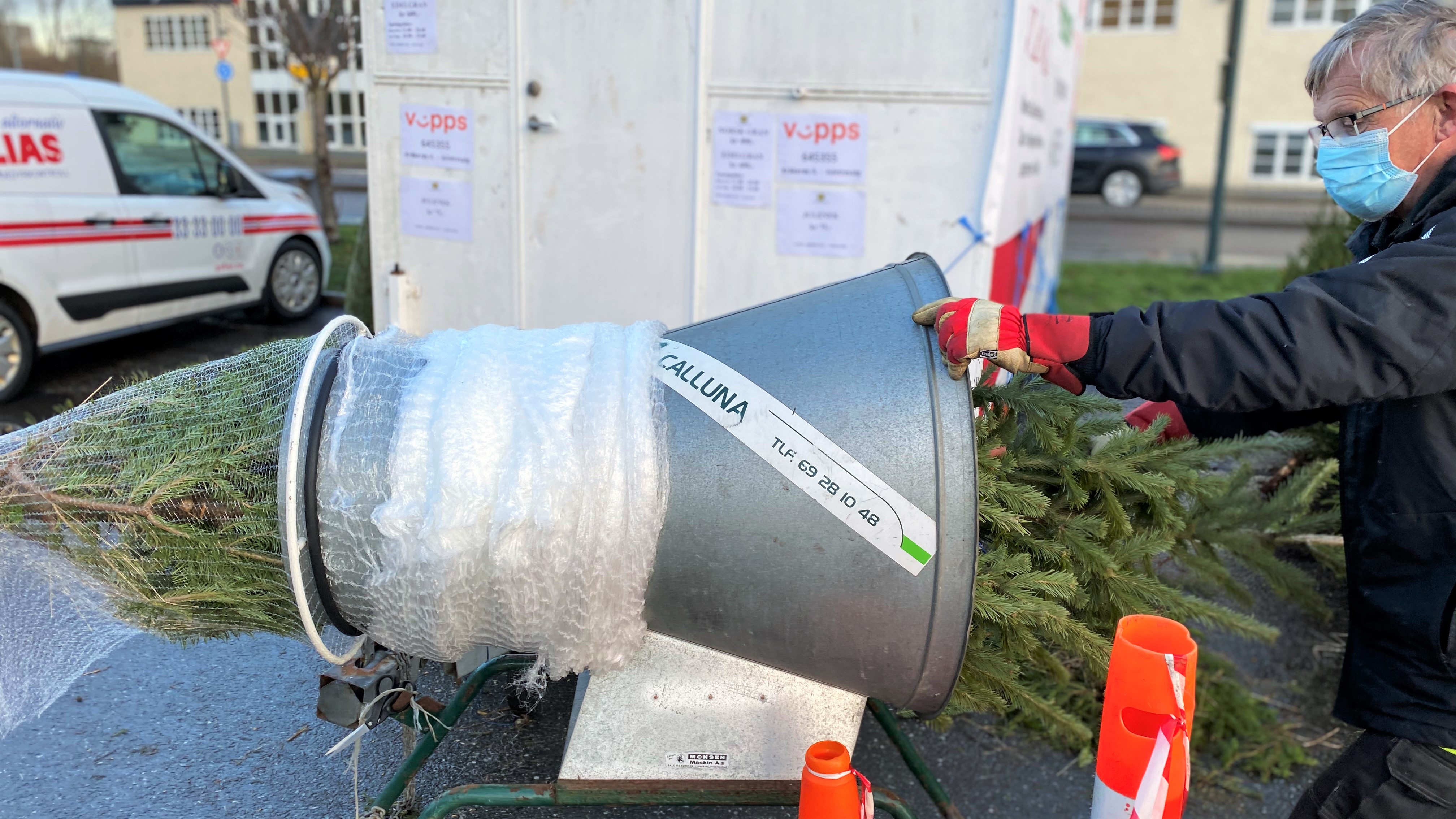 Leif Erlandsen fra Kråkerøy IL pakker et juletre inn i netting før kunden kan få det med seg hjem. Årlig selger klubben rundt 400 trær på dugnad.