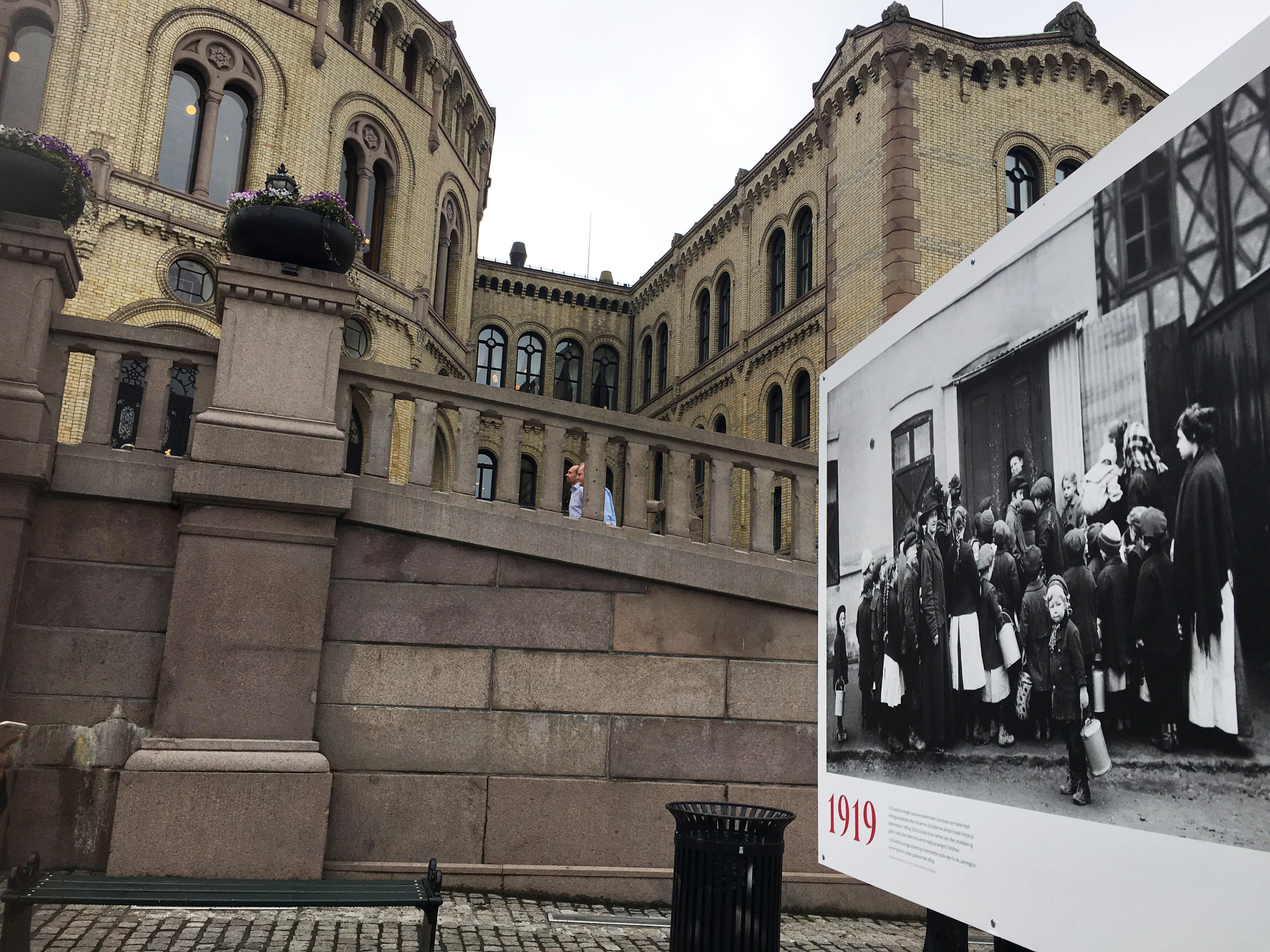 Bildet viser en fotoplakat utenfor Stortinget.