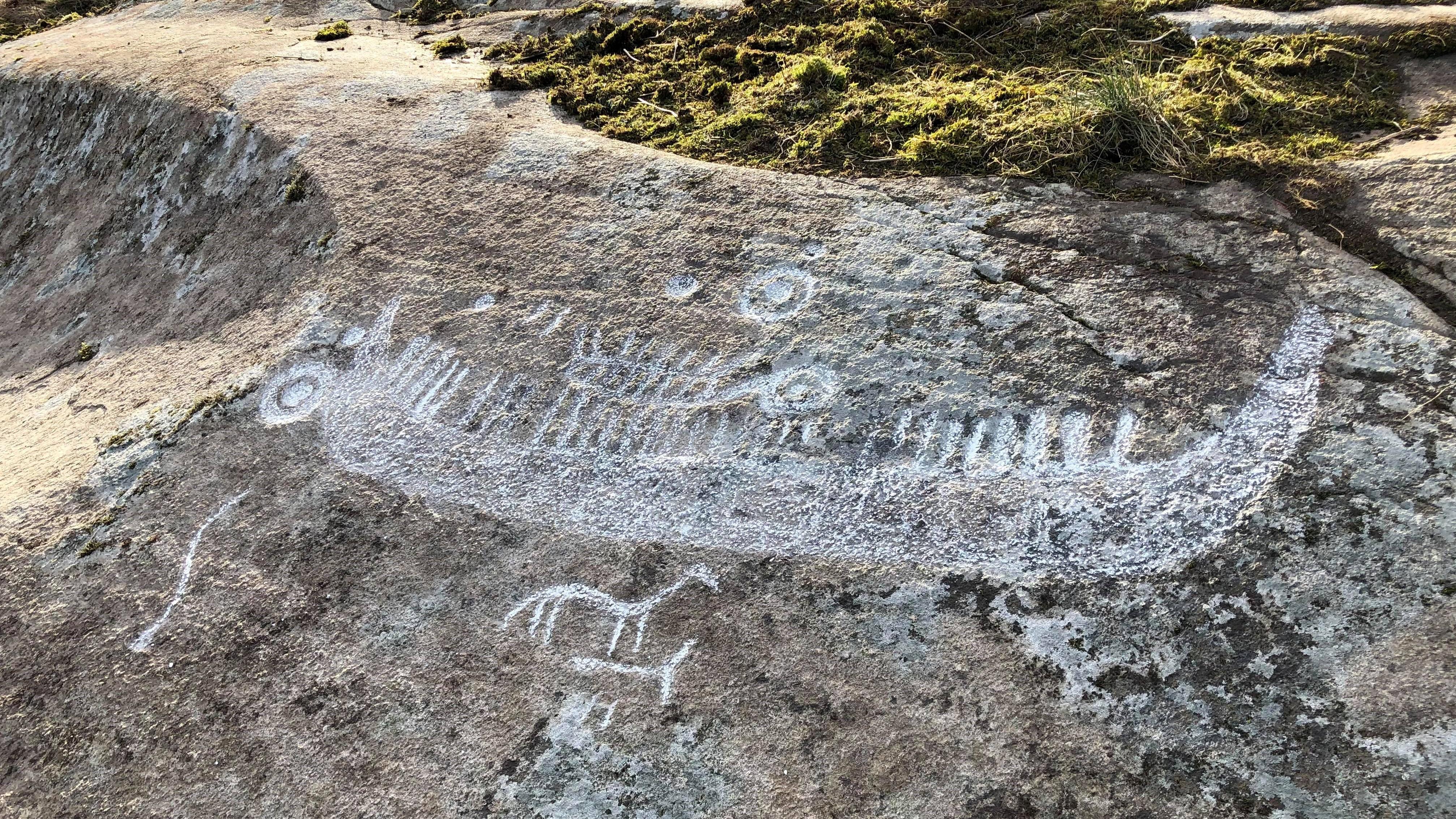 Båten, med sirkler og skålgroper, er tegnet opp med kritt for å synes bedre.