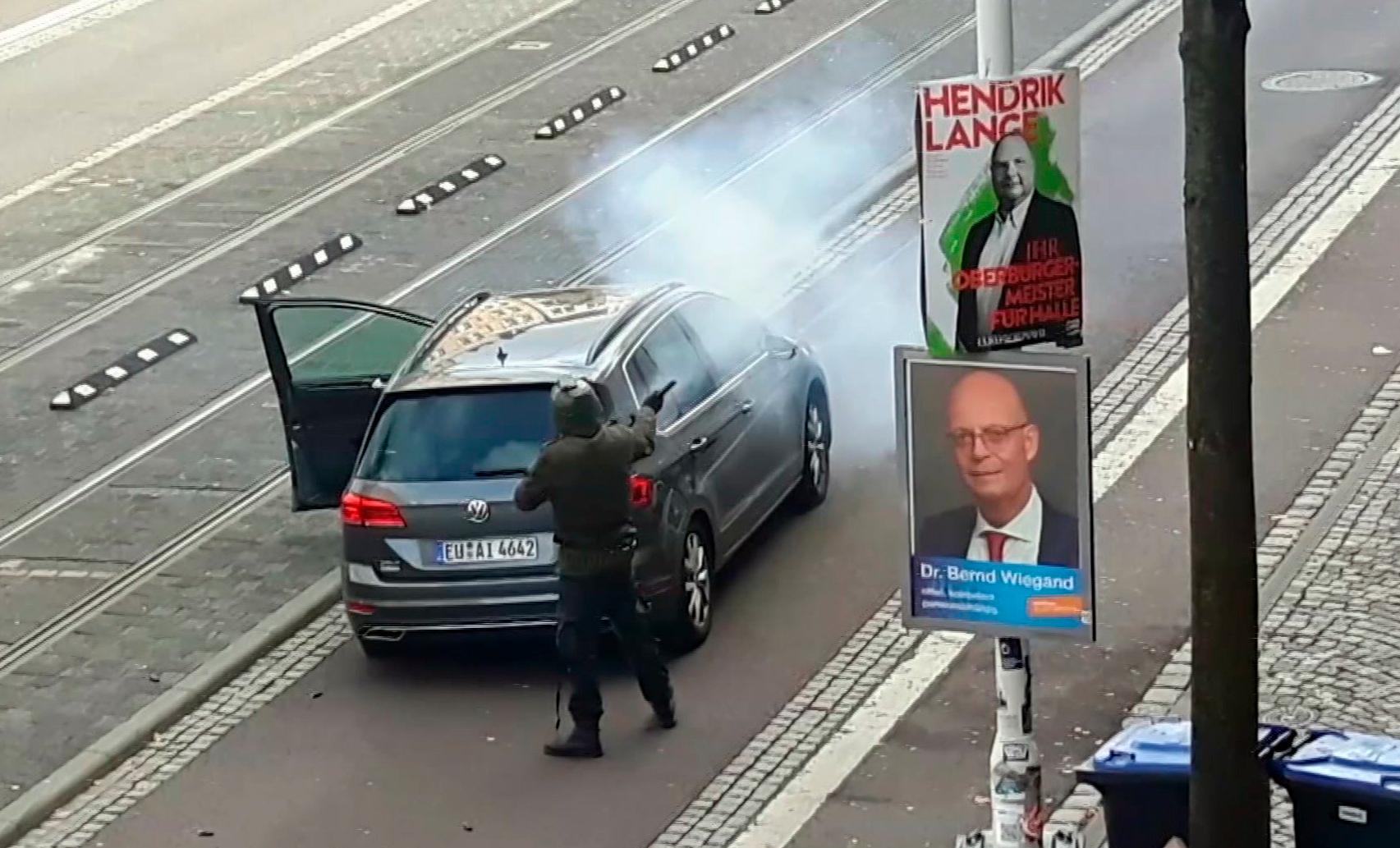 In this image taken from video made available by ATV-Studio Halle, a man shoots from long-barrelled gun, in Halle, Germany, Wednesday Oct. 9, 2019. A heavily armed assailant ranting about Jews tried to force his way into a synagogue in Germany on Yom Kippur, Judaism's holiest day, then shot two people to death nearby in an attack that was livestreamed on a popular gaming site. (ATV-Studio via AP)