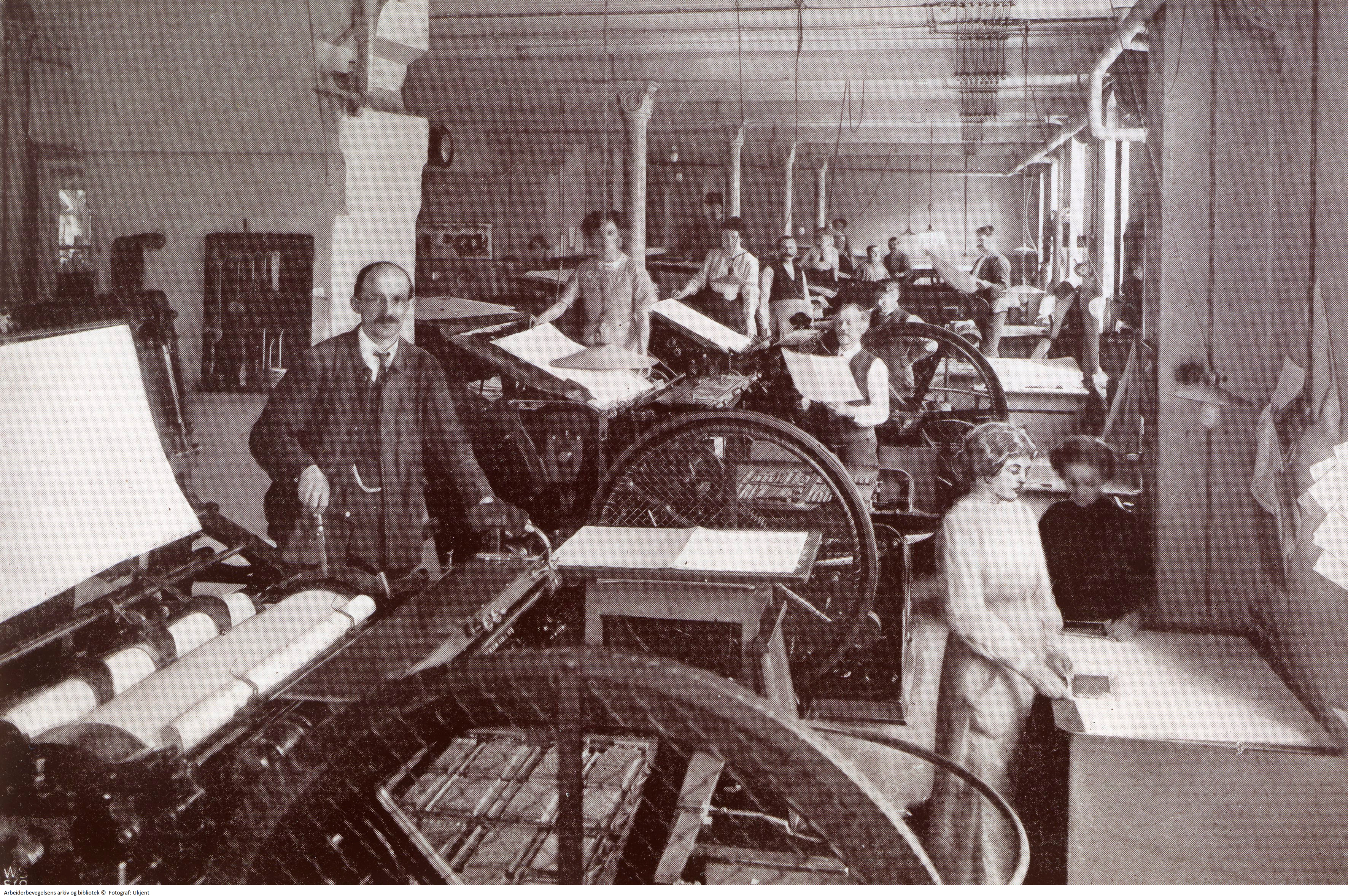 Påleggersker og andre trykkeriansatte i maskinsalen hos Grøndahl & Søn boktrykkeri, 1890–1900.