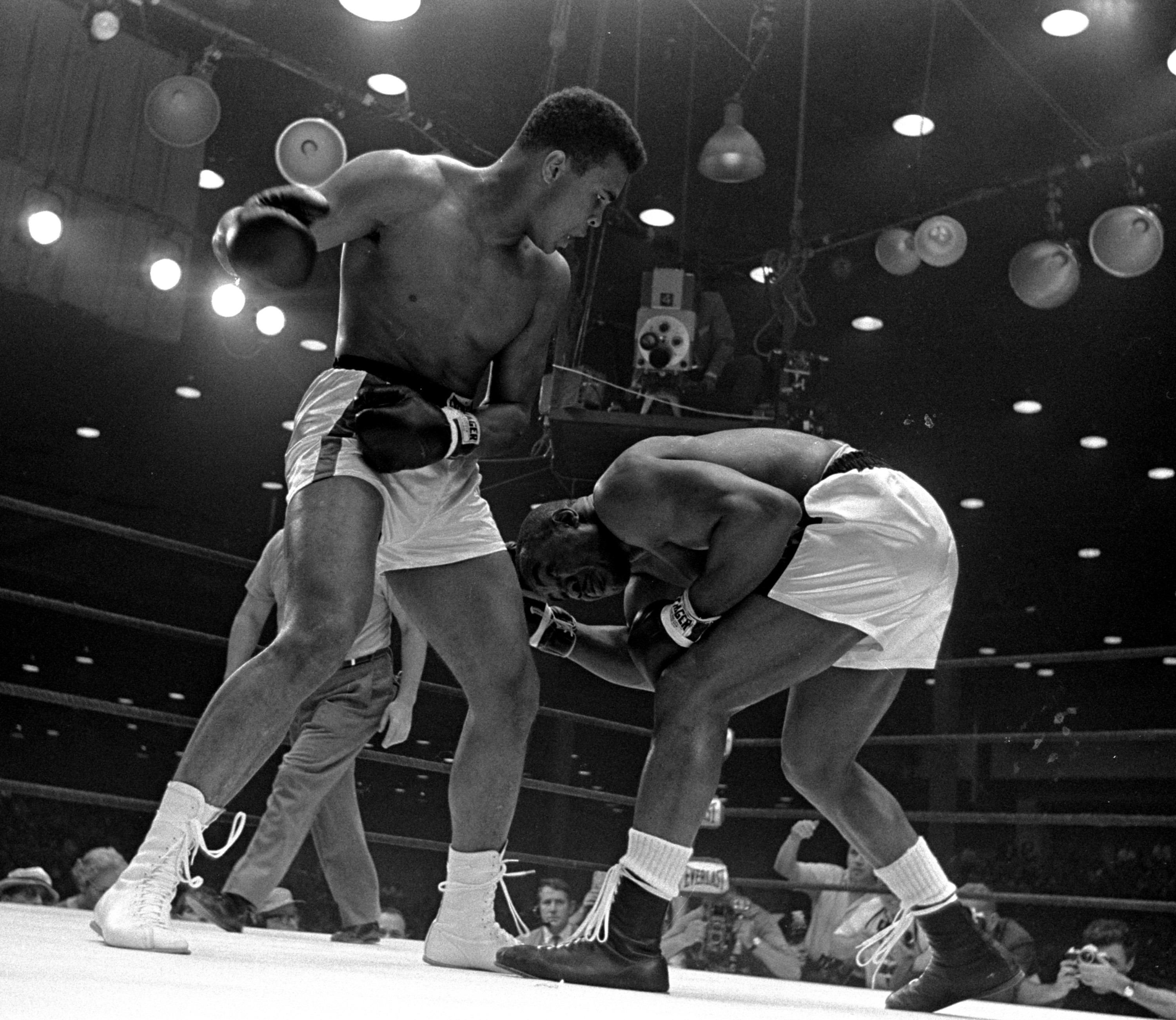 Sonny Liston, right, ducks low and weaves to escape a punch from Cassius Clay's cocked right fist during the 5th round of the heavyweight title fight in Miami Beach, Florida, February 25, 1964.  Clay won on a seventh round technical knockout. (AP Photo/stf)