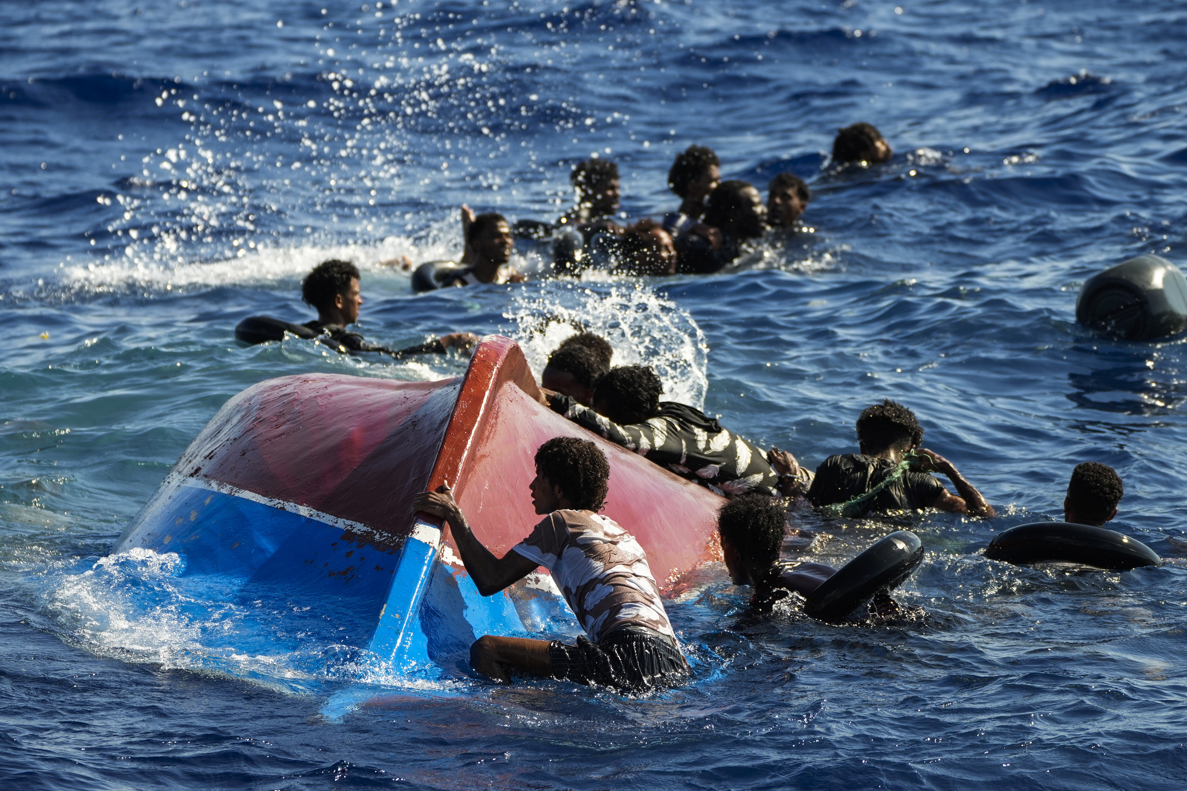 Bildet viser migranter holder seg flytende utenfor den italienske øya Lampedusa i august 2022.