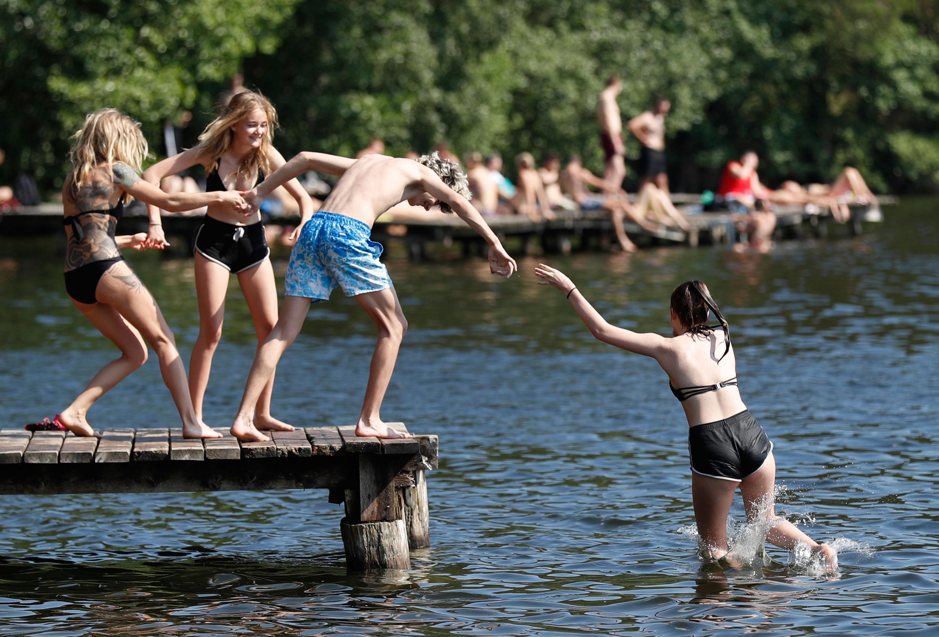 Bildet viser folk som bader i sjøen nær Vilnius i Litauen.