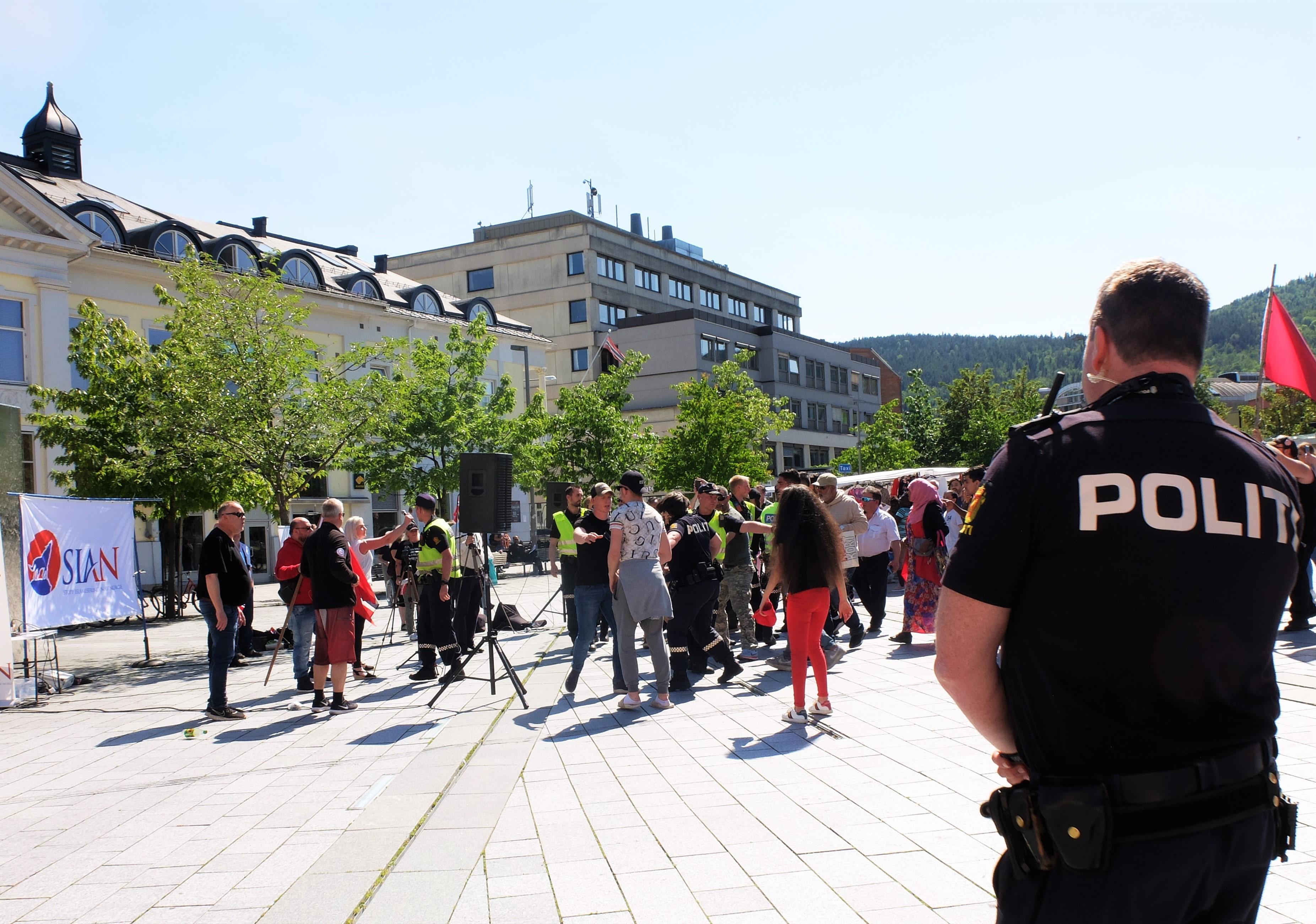 Politiet griper inn og avslutter SIANs taletid rundt ti minutter før tiden, etter at representanter har gått utover tillatelsen de fikk til å ha stand og tale på Strømsø torg i tre timer lørdag formiddag. Det skjer etter at Anna Bråten har hisset opp stemningen ved å peke ut enkeltpersoner i publikum og kaste koranen i bakken foran folkemengden. FOTO: KATRINE STRØM