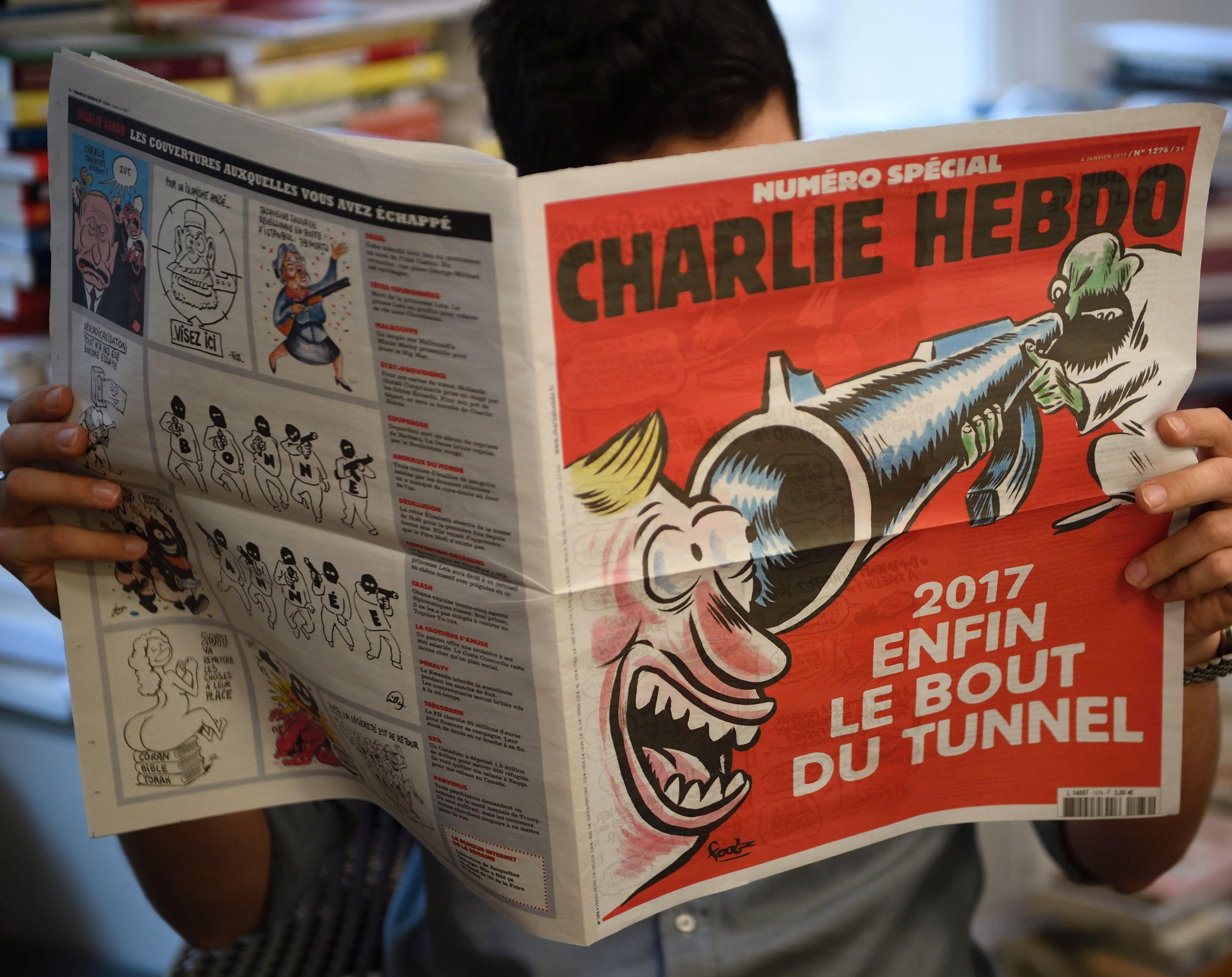 En journalist leser siste nummer av Charlie Hebdo, som kom denne uka.