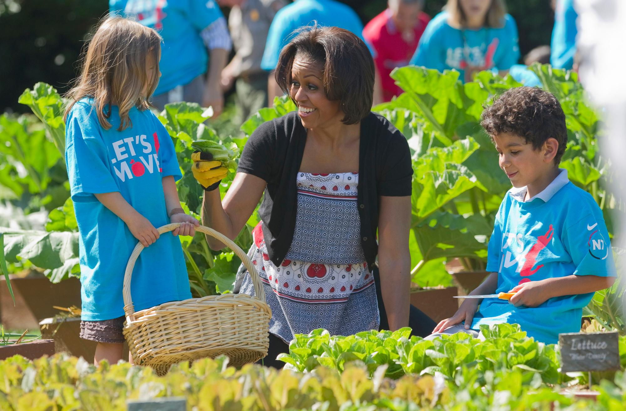 First lady Michelle Obama tends the White House garden in Washington, Friday, June 3, 2011, with a group of children as part of the "Let's Move!" campaign.  (AP Photo/Evan Vucci)