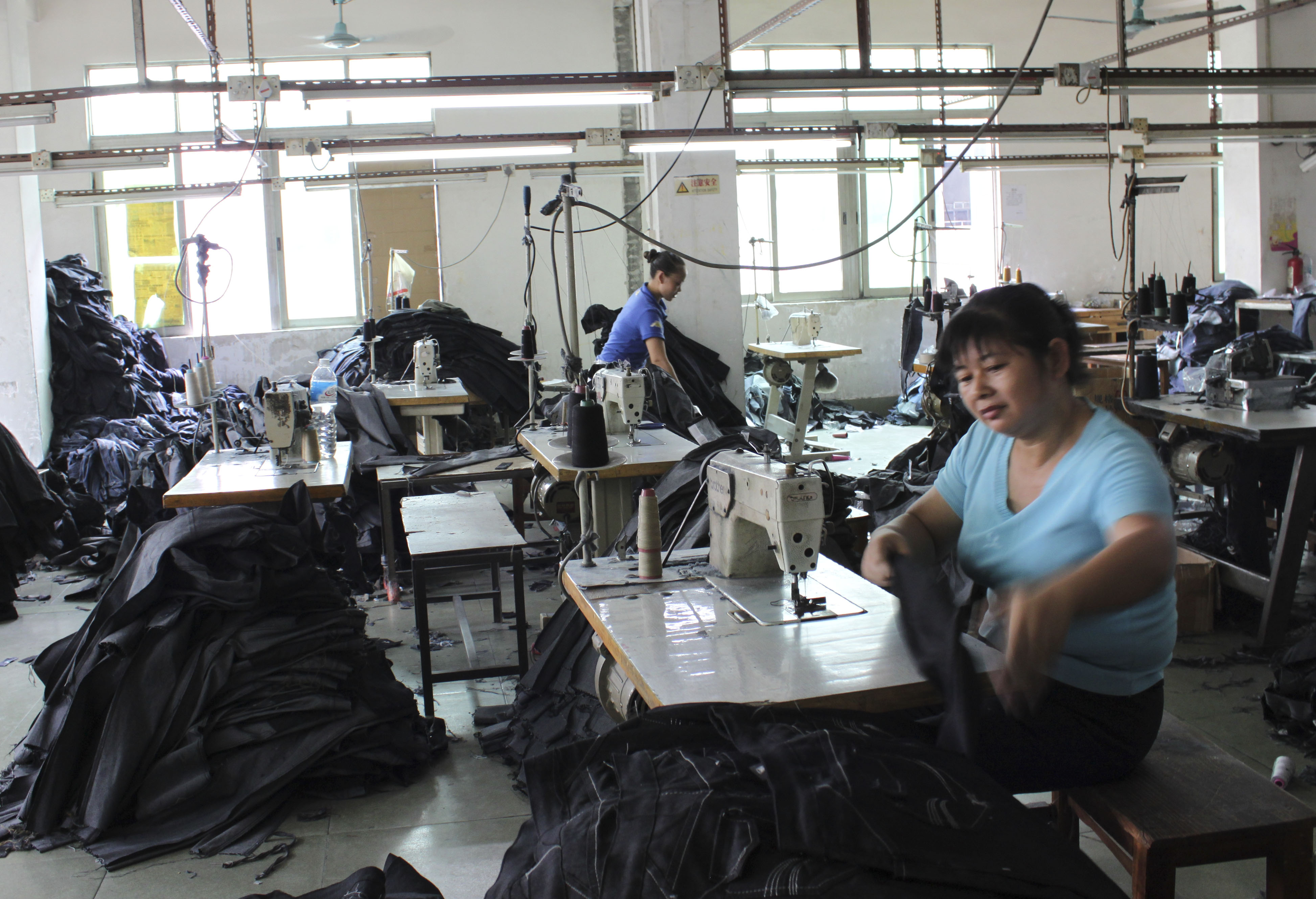 In this photo taken Thursday, Aug. 27, 2009, employees work in a blue jeans factory in Xintang township near Guangzhou, in South China's Guangdong province. The labor crunch is another sign that the Chinese economy _ the world's third largest _ is bouncing back from the global downturn, invigorated by government stimulus spending and a flood of cheap bank loans.  (AP Photo/William Foreman)