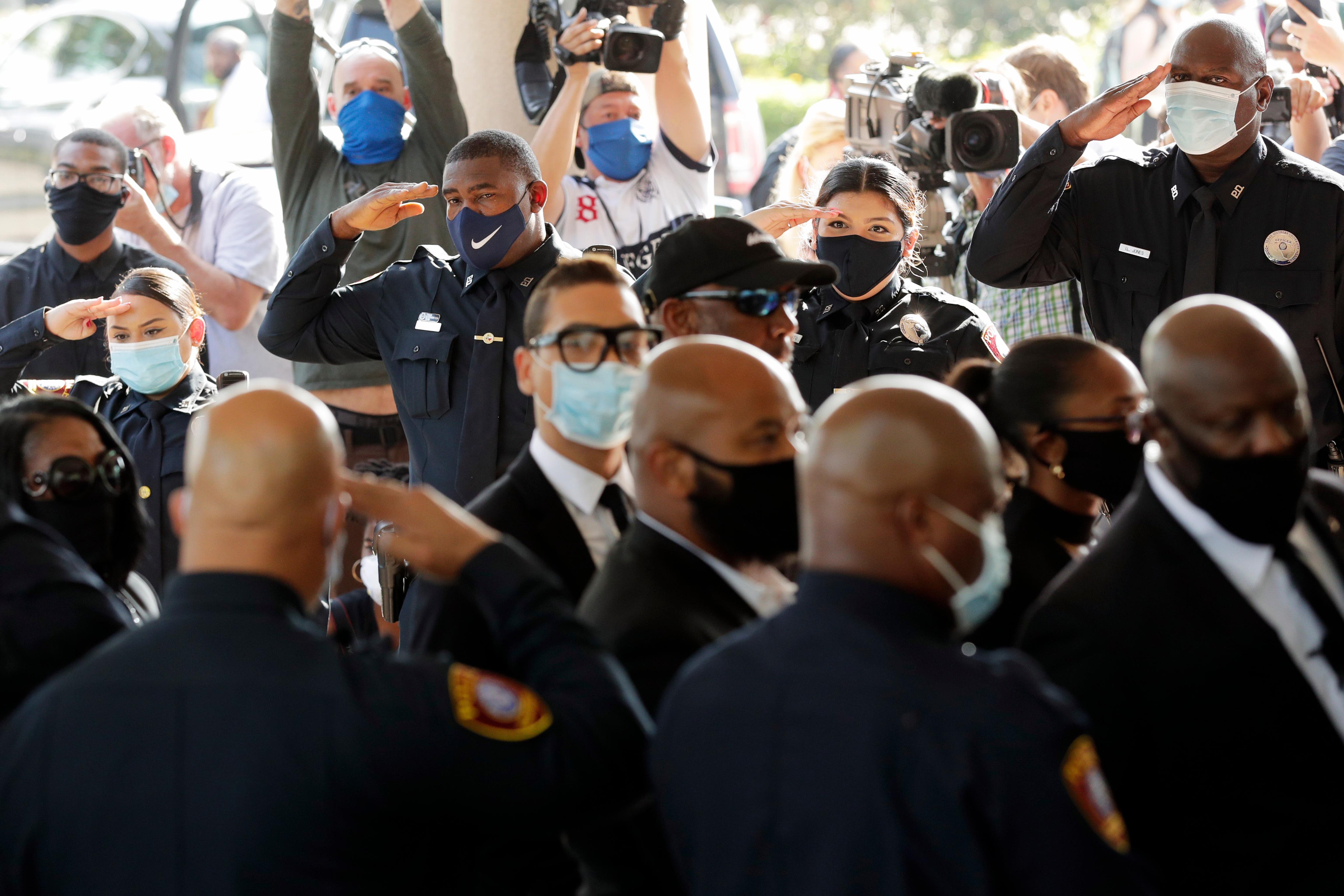 Texas Southern University police salute as family and guests arrive for George Floyd's funeral service at The Fountain of Praise Church on Tuesday, June 9, 2020, in Houston. (AP Photo/Eric Gay)