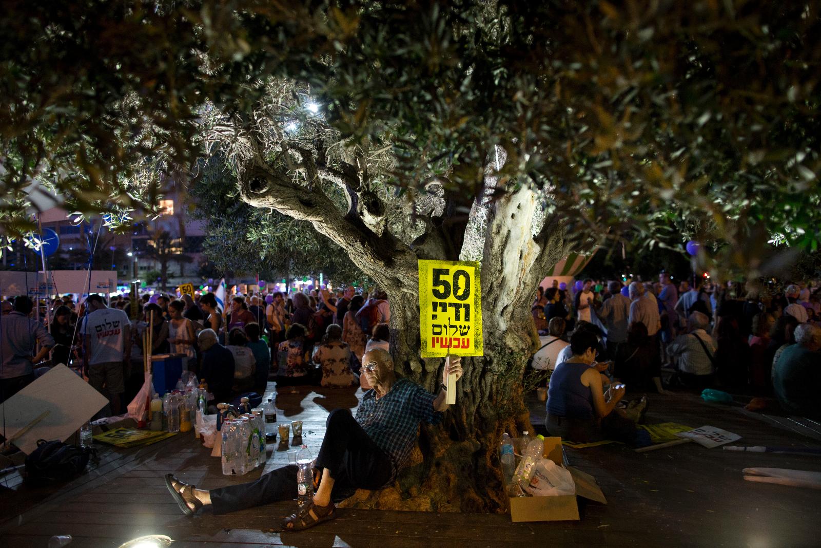 Israeler i Tel Aviv med ett plakat som lyder ”50 år är nog  fred nu”.