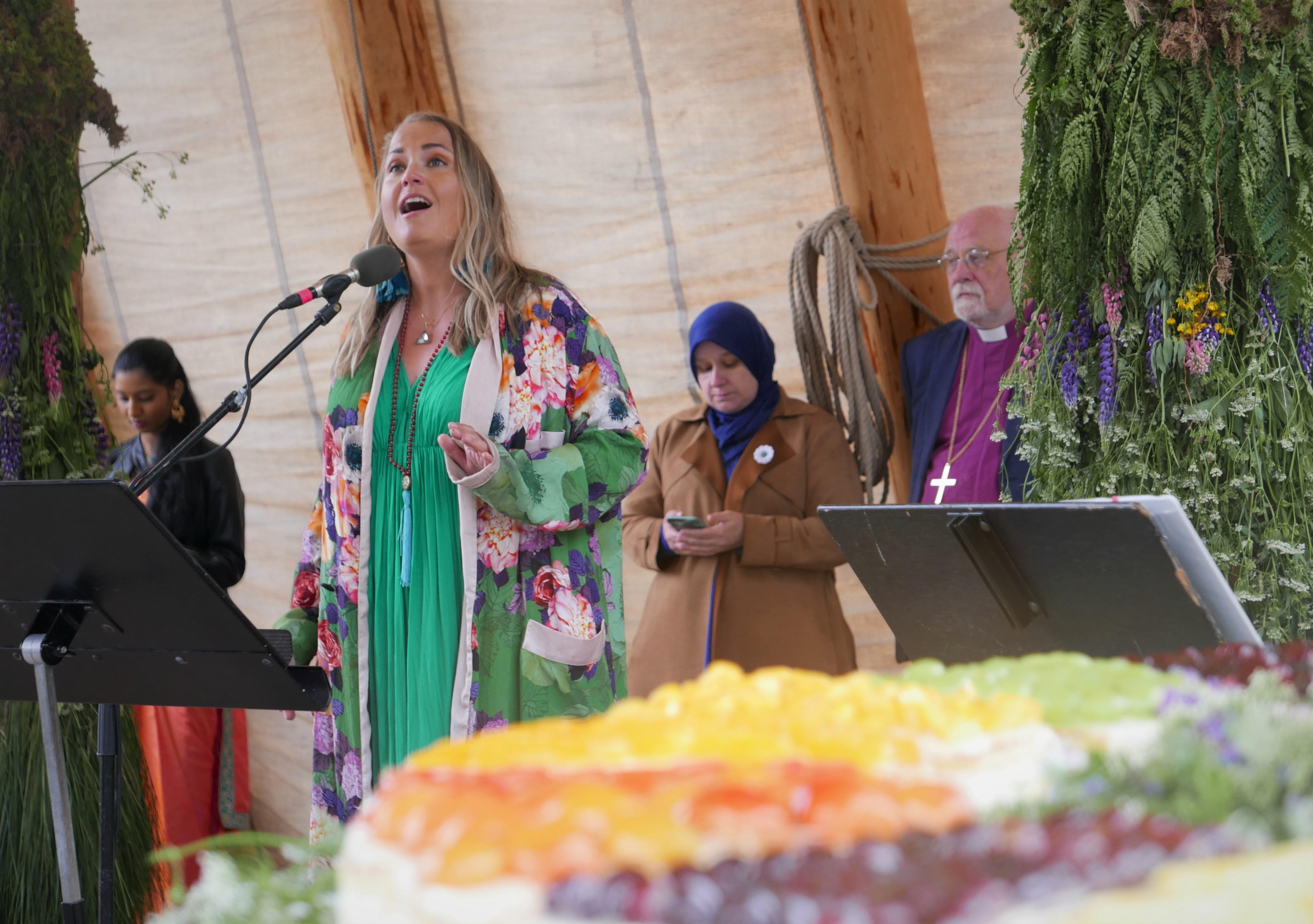 Helene Bøksle sang blant annet «Änglamarken» av Evert Taube. I forgrunnen ses bærekraftkaka fra Fasvo. I bakgrunnen, hindu Yuhashinee Shankkar (fra venstre), muslimske Velisa Salihovic og biskop Atle Sommerfeldt.