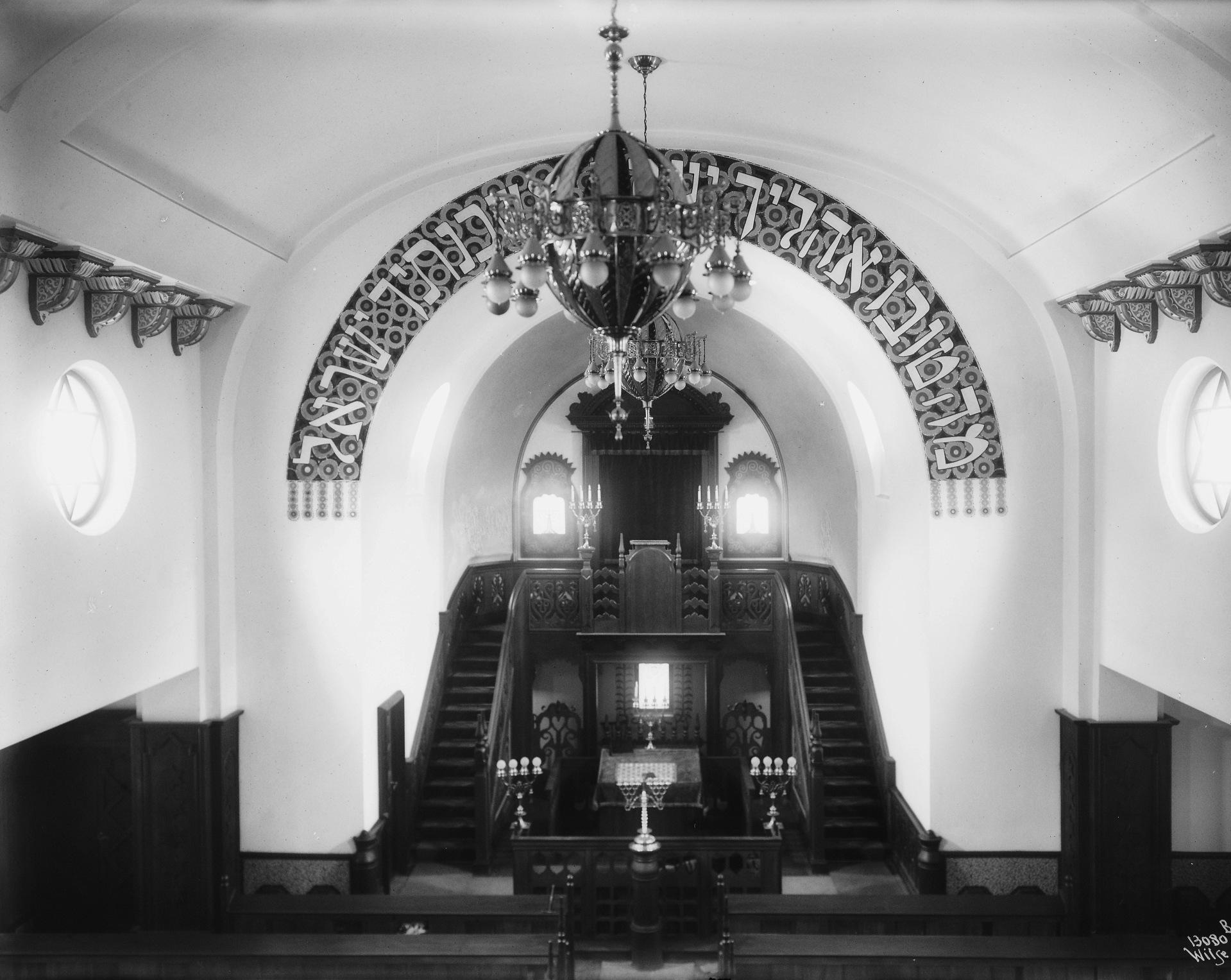 Innvielsen av synagogen 21. mai 1920 ble innledet med ordene som pryder buen over fronten: «Hvor yndige er dine telte, Jakob, dine boliger, Israel». Opp trappa er Torah-skapet hvor Torah-rullene med kledning og sølv oppbevares. Foto fra ca. 1920: Anders B. Wilse, Oslo Museum