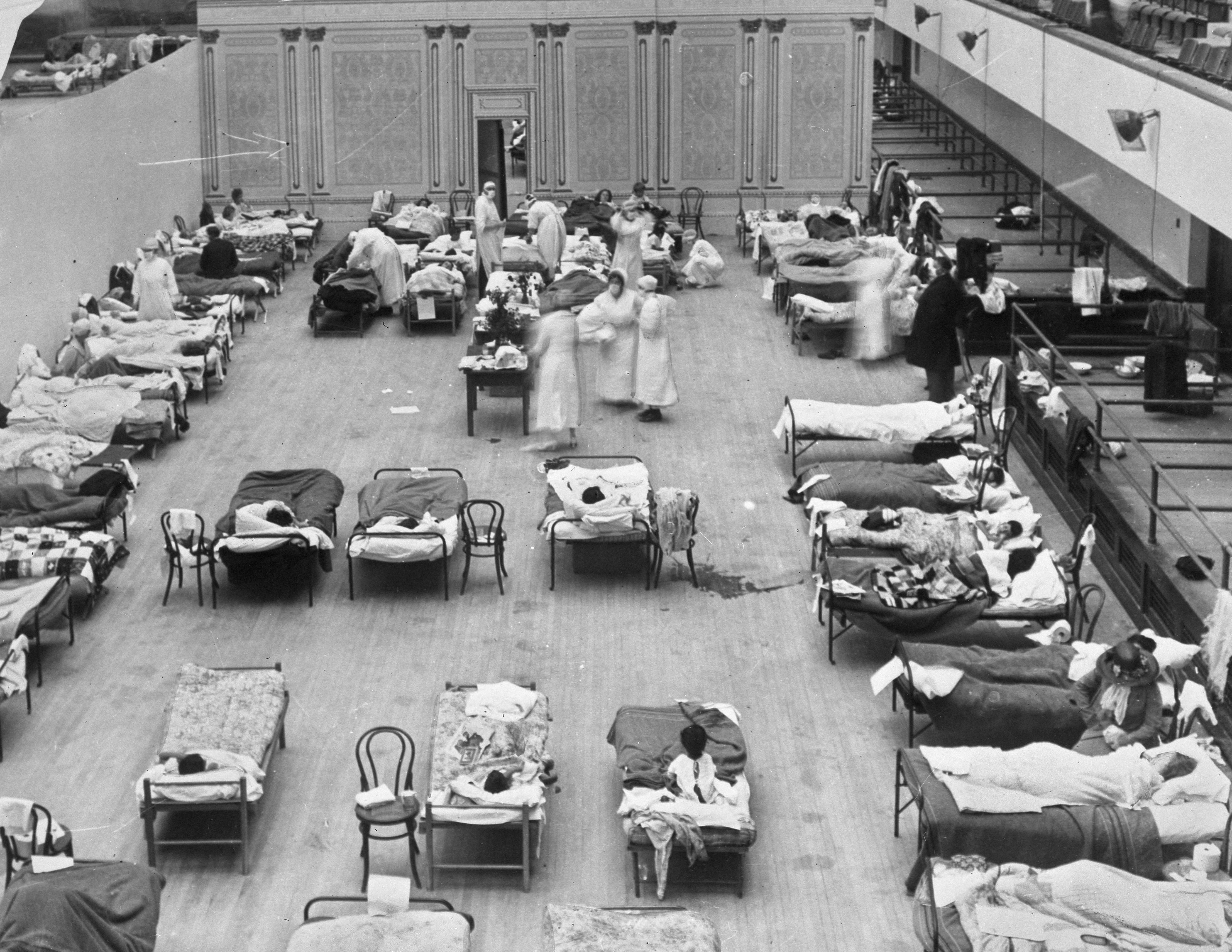 FILE - In this 1918 photo made available by the Library of Congress, volunteer nurses from the American Red Cross tend to influenza patients in the Oakland Municipal Auditorium, used as a temporary hospital. (Edward A. "Doc" Rogers/Library of Congress via AP, File)