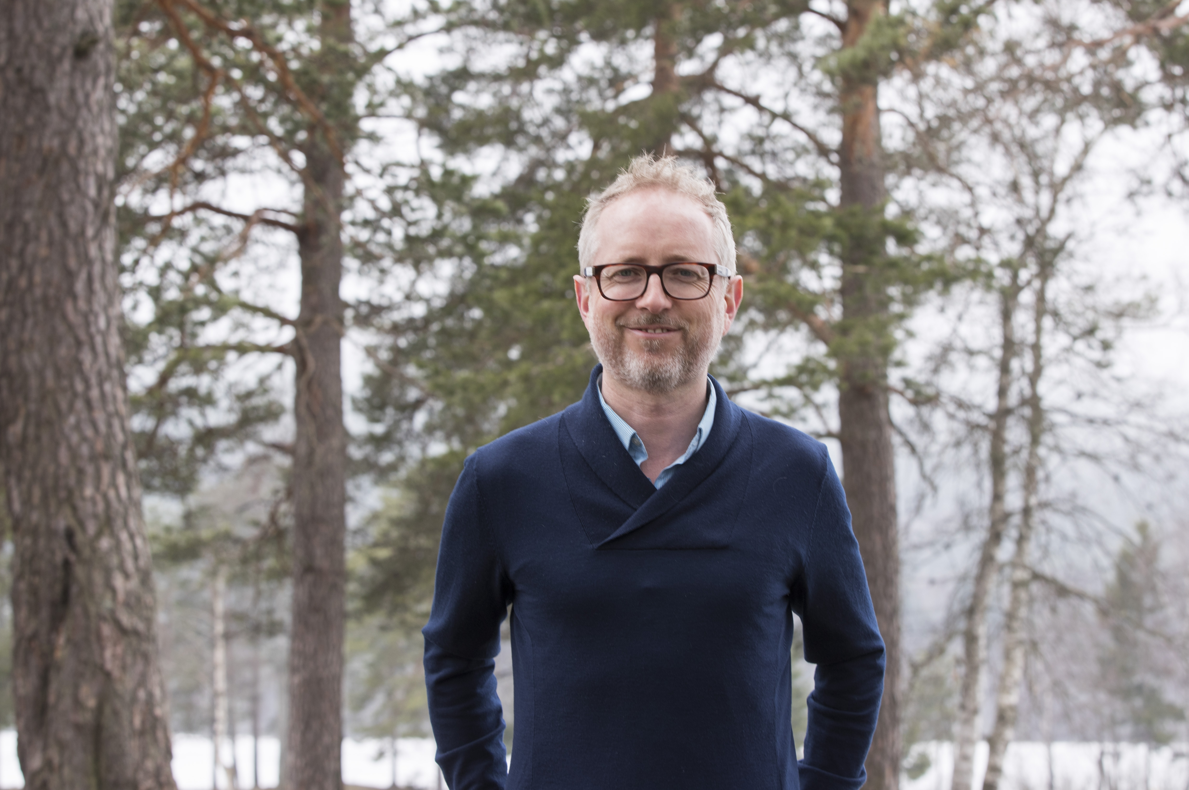 Norad-sjef Bård Vegar Solhjell poserer foran noen trær.