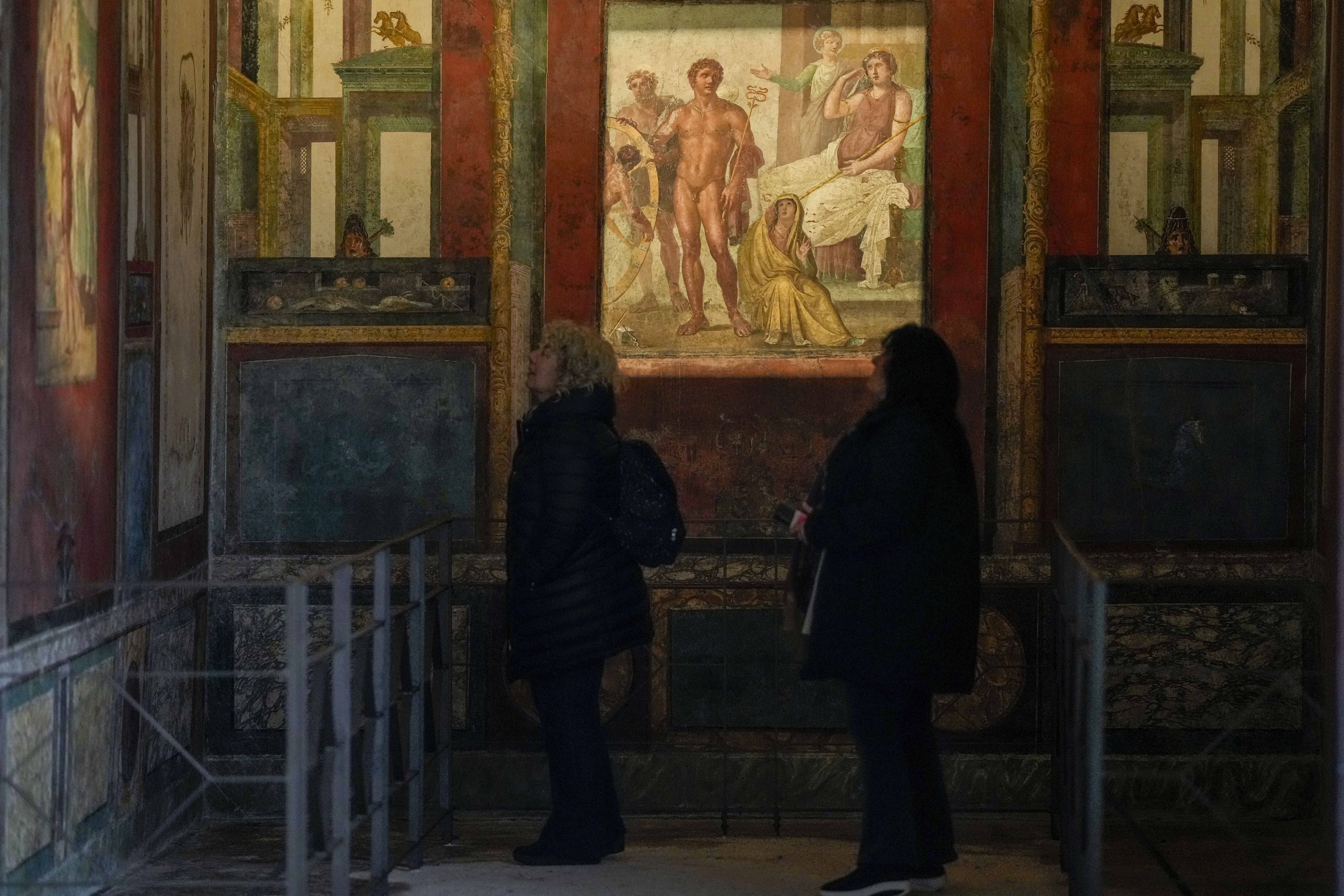 Besøkende beundrer fresker i et «triclinium», eller spisestue, kalt «Hall of Ixium», en del av den gamle romerske Domus Vettiorum, huset til Vettii, i Pompeiis arkeologiske park. Vettii-huset er nyrestaurert og åpnet for publikum igjen 11. januar. Foto: Andrew Medichini / AP / NTB