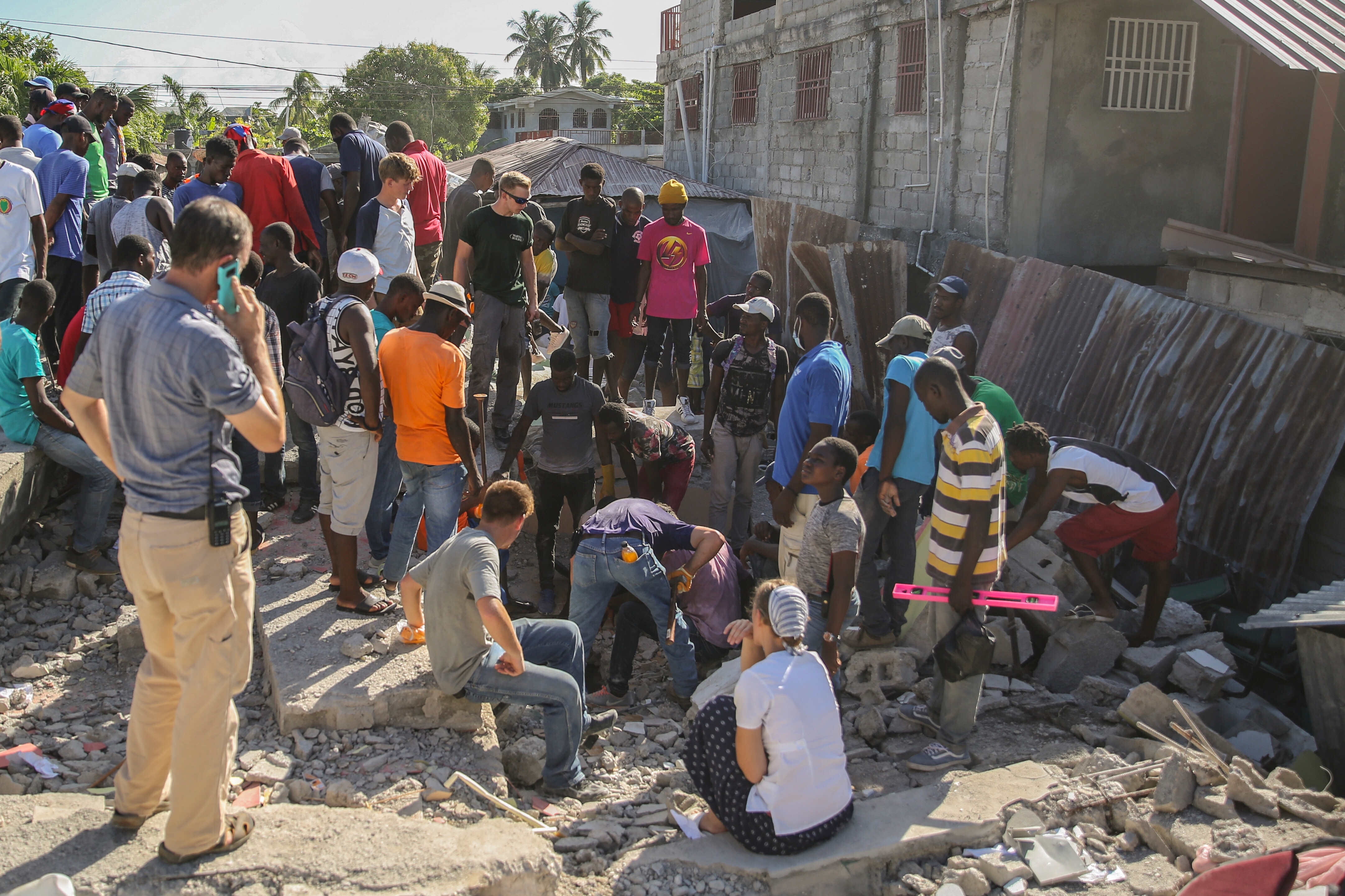 Sökande efter överlevande bland rasmassorna i staden Les Cayes på Haiti.