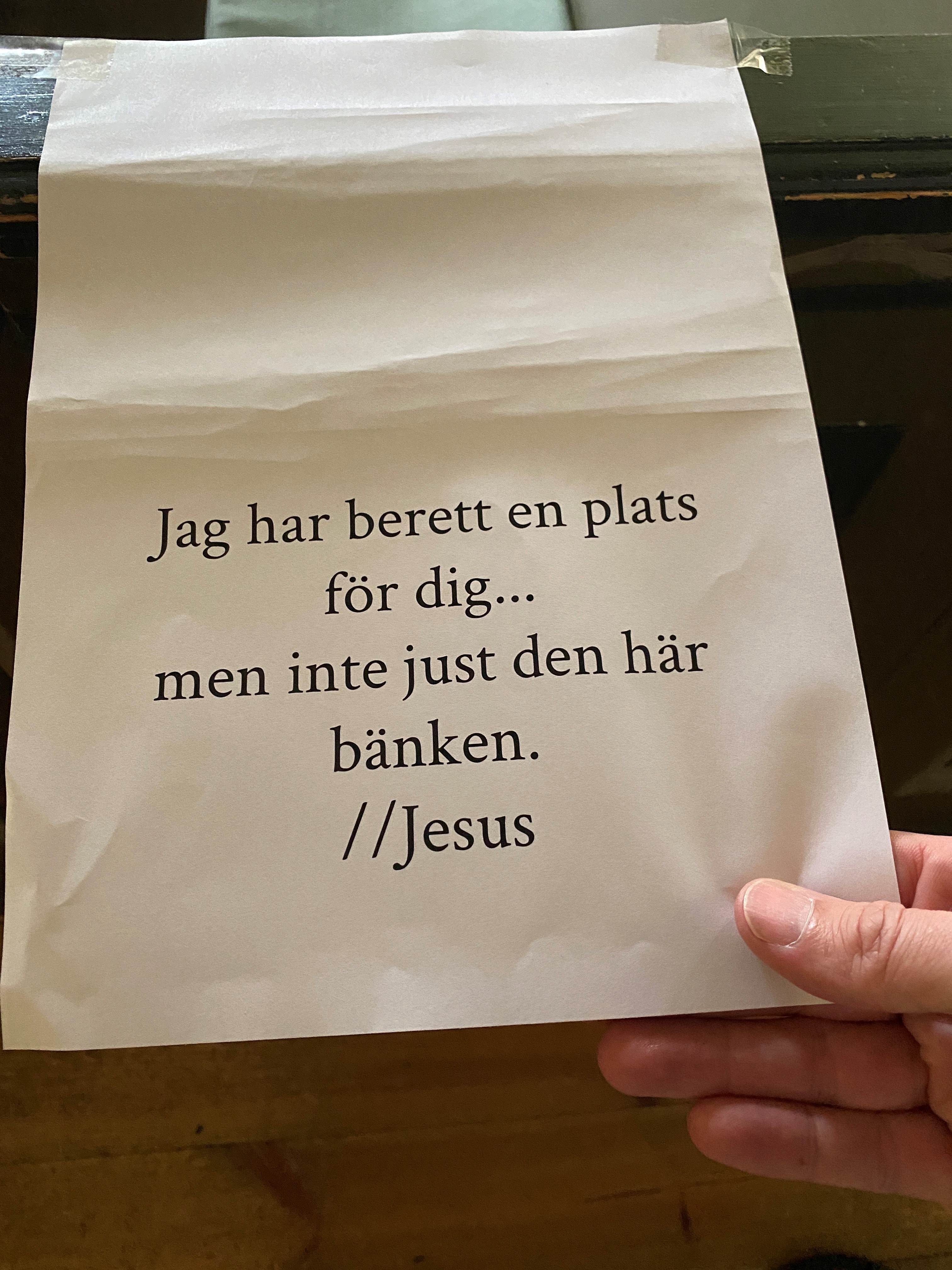 Bild på lapp i Torpa kyrka med texten "Jag har berett plats för dig...men inte just den här bänken. Jesus"