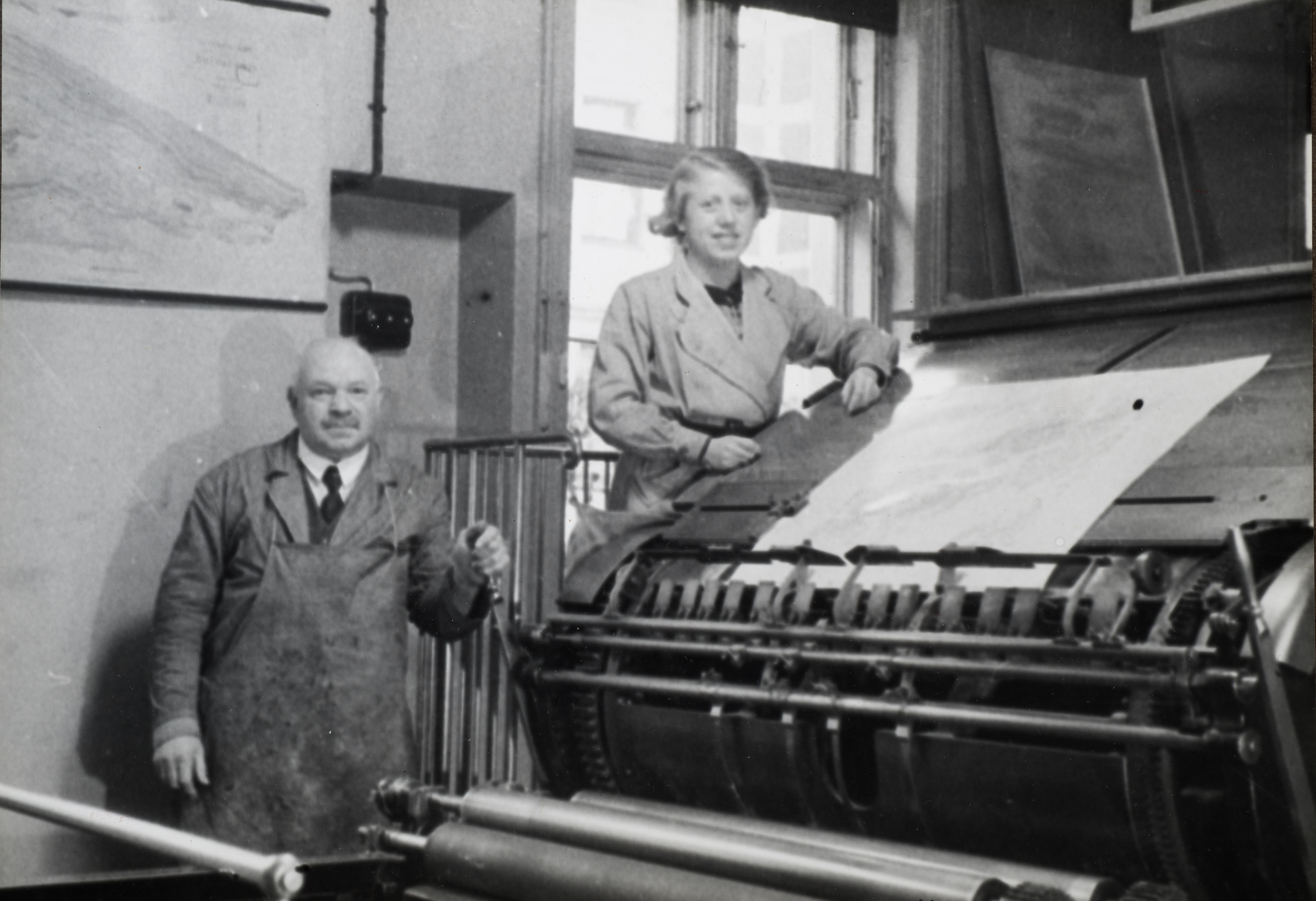 Påleggerske frk. Hjørdis Jacobsen og trykker O. Berger ved hurtigpressa Johannisberg i Trykkerisalen i Norges geografiske oppmåling St. Olavsgt 32 i 1930.