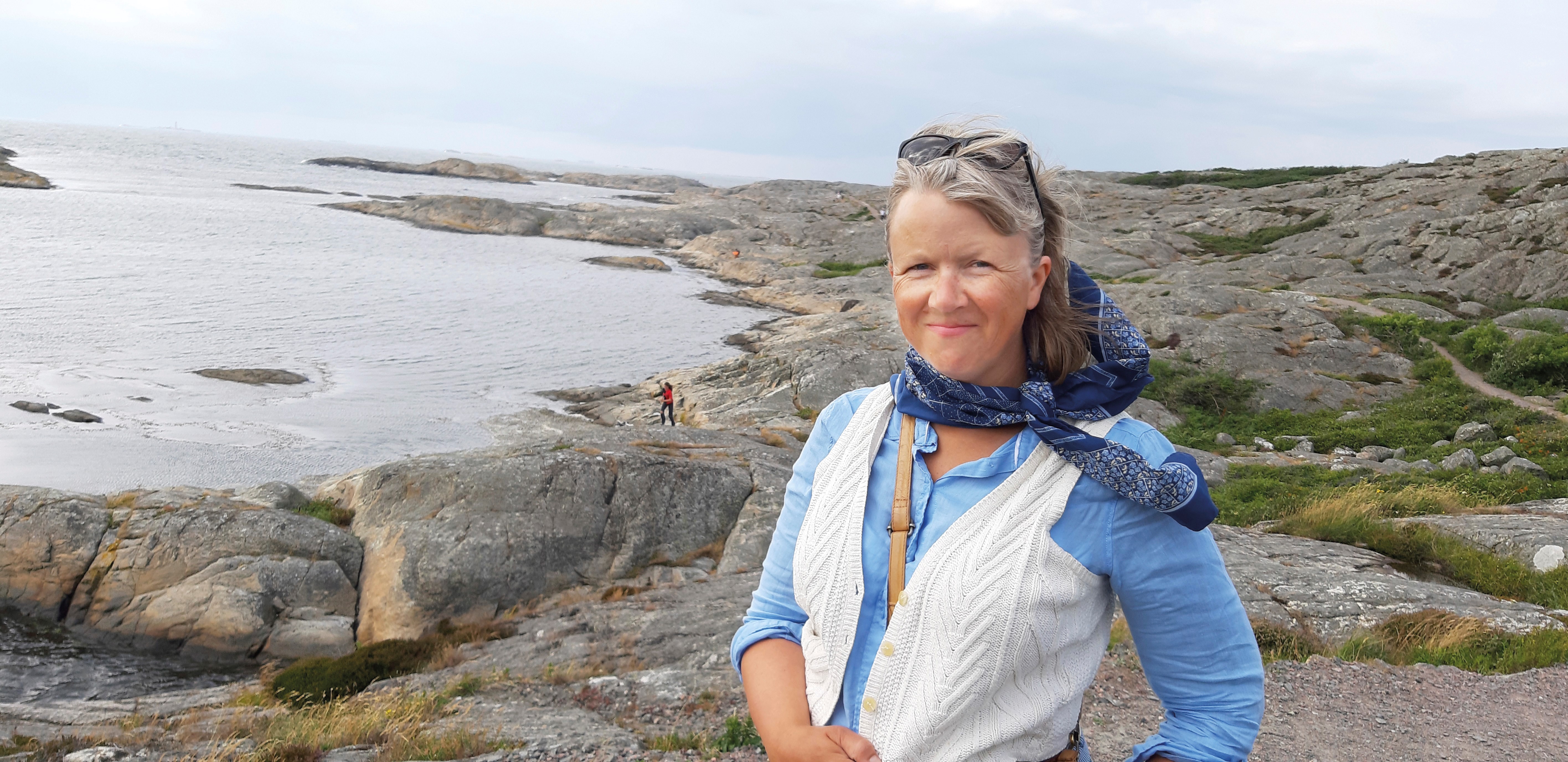 Anna-Sophia Bonde framför ett klipplandskap mer mot en havsvik.