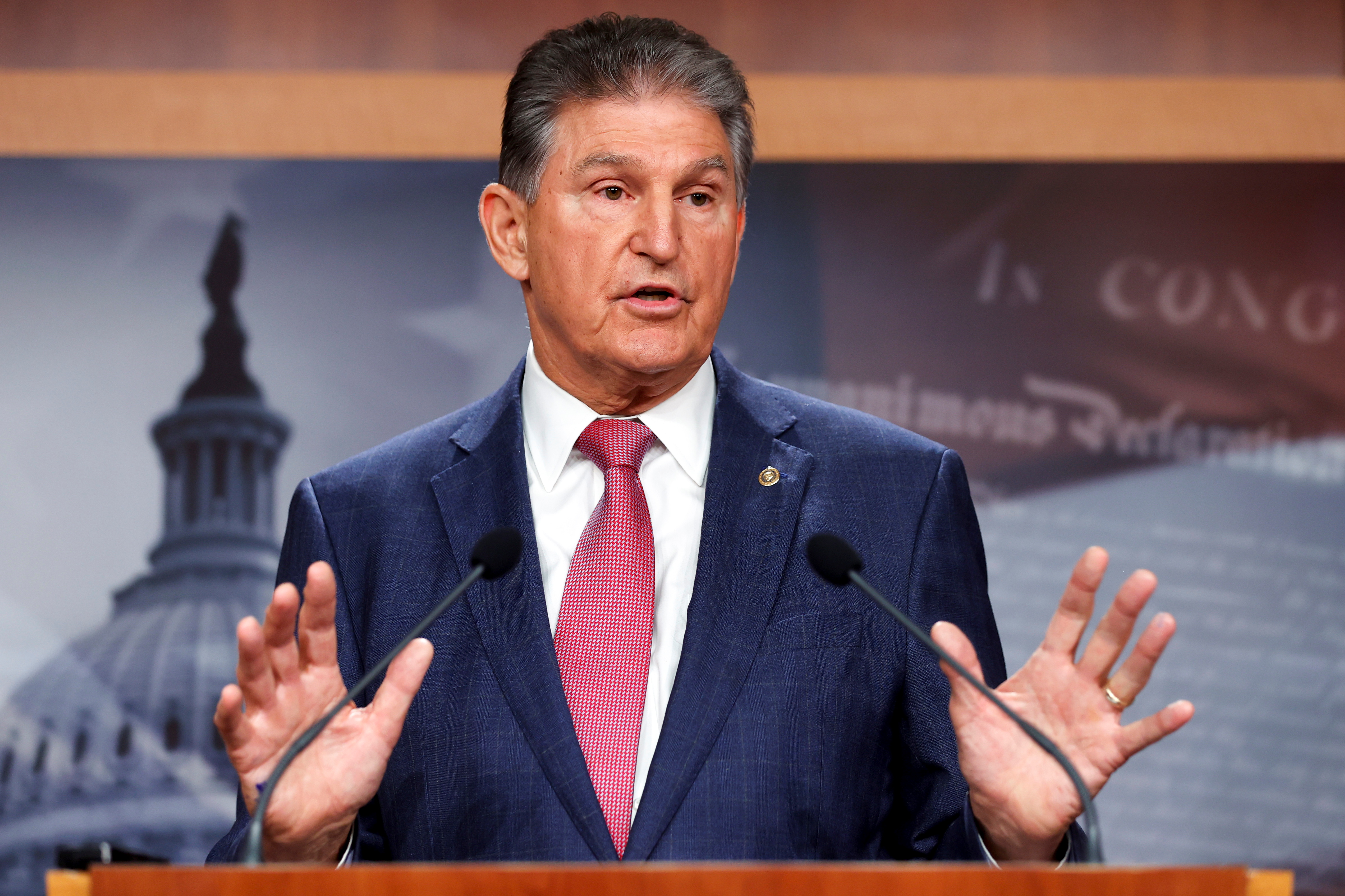 Senator Joe Manchin holder opp hendene mens han snakker til pressen.