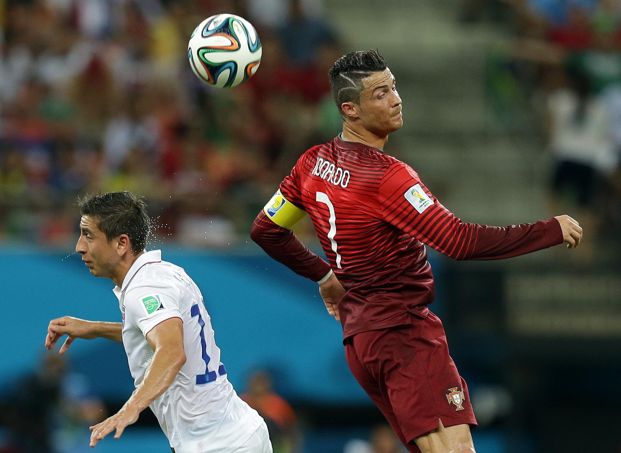 Portugal's Cristiano Ronaldo heads the ball over United States' Alejandro Bedoya during the group G World Cup soccer match between the USA and Portugal at the Arena da Amazonia in Manaus, Brazil, Sunday, June 22, 2014. (AP Photo/Martin Mejia)