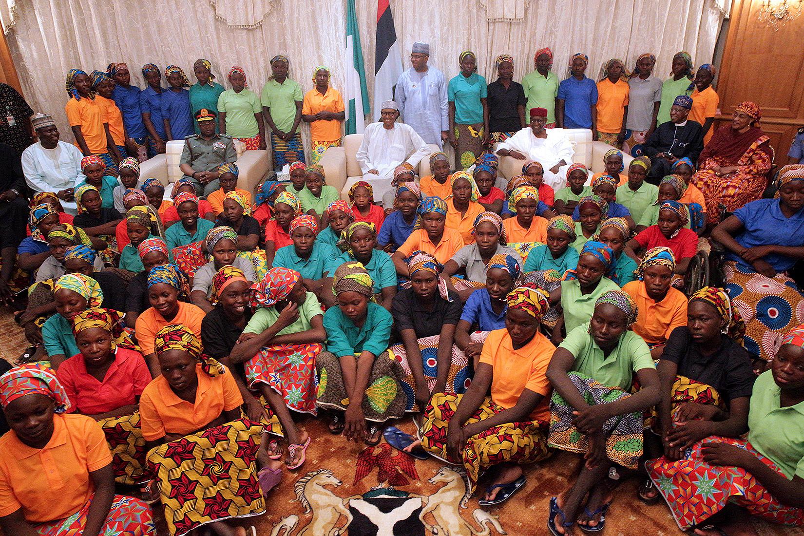 In this photo released by the Nigeria State House, Nigeria President, Muhammadu Buhari, centre, meets with Chibok school girls recently freed from Nigeria Extremist captivity in Abuja, Nigeria, Sunday, May 7, 2017. Five Boko Haram commanders were released in exchange for the freedom of 82 Chibok schoolgirls kidnapped by the extremist group three years ago, a Nigerian government official said Sunday, as the girls were expected to meet with the country's president and their families. (Bayo Omoboriowo/Nigeria State House via AP)