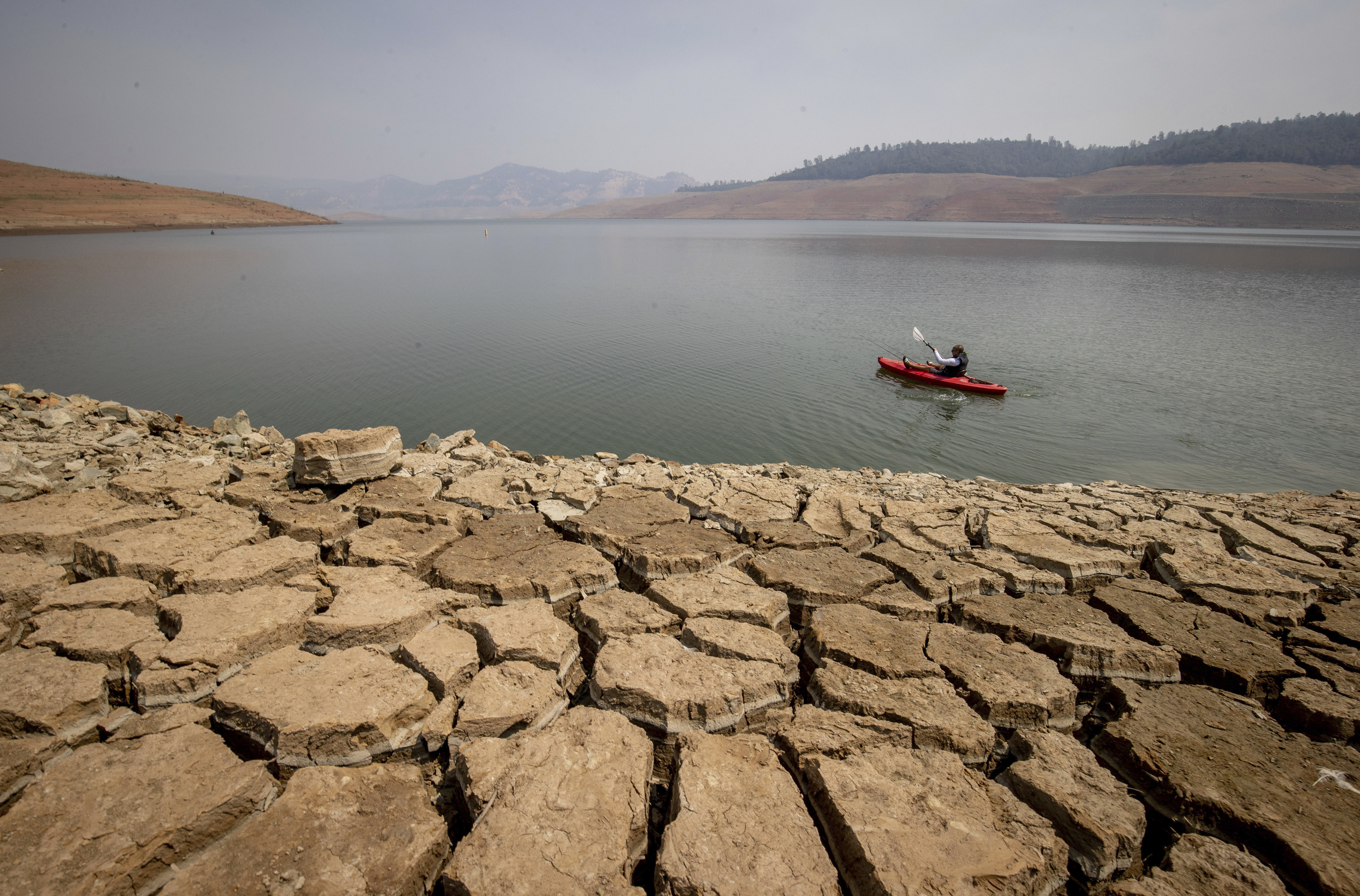 En kajakker padler på Lake Oroville i California i august, tross ekstremt lav vannstand. Klimaendringer og større grad av kunnskap vil føre til at flere tar miljøbevisste valg for å få en endring – og griper sjansen til å oppleve det de ønsker før det er for sent. Foto: Ethan Swope / AP / NTB