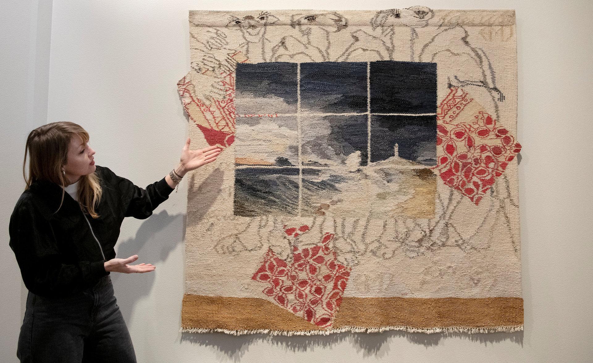 Seniorkurator Trude Schjelderup-Iversen i Koro viser fram Else Marie Jakobsens (1927–2012) feministiske bildevev «Dromedarene og tekstilkunsten» fra 1994, som ble laget i protest over at mannlige kunstkritikere ignorerer kvinners kunst generelt og tekstilkunst spesielt.