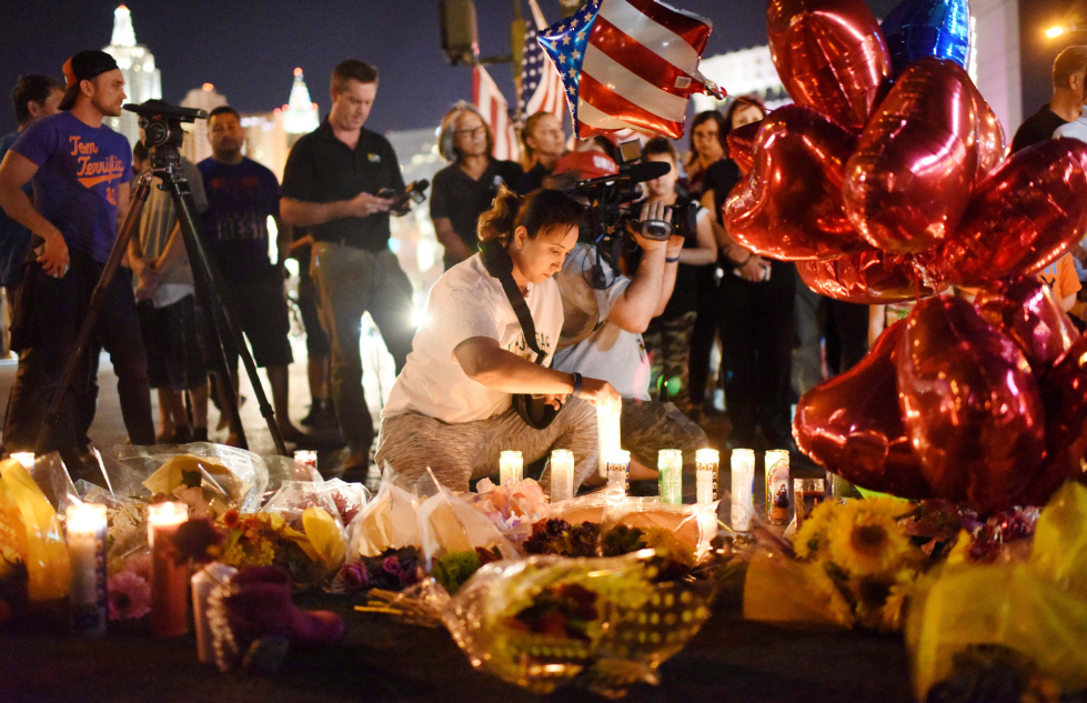 SØRGER: En kvinne tenner lys ved Mandalay  hotell i Las Vegas, for ofrene for den verste skytemassakren i nyere amerikansk historie.