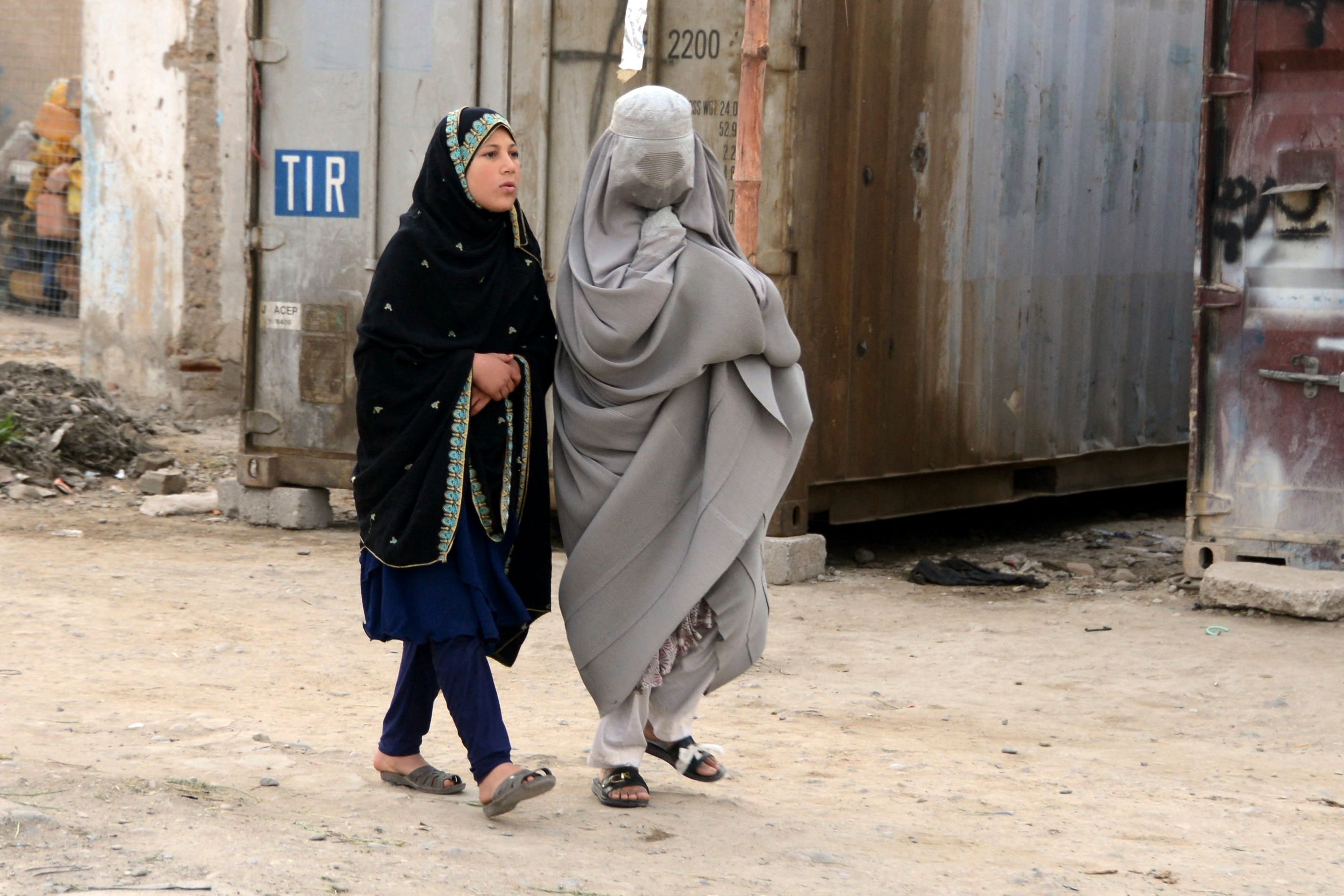 En burkakledd kvinne og et barn går på gata i Kandahar i Afghanistan.