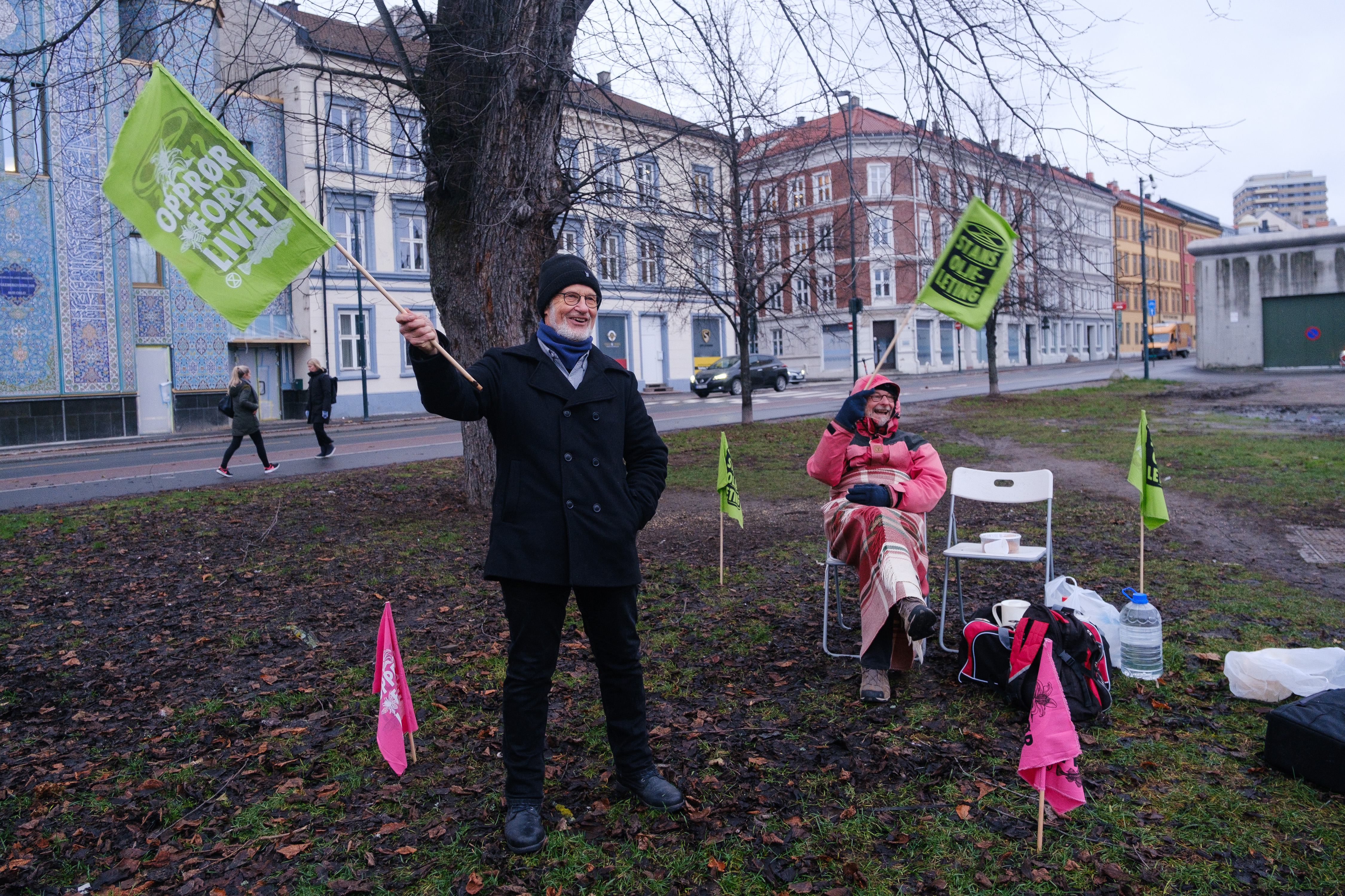 To medlemmer av Extinction Rebellion jubler for en aktivist som har sittet på glattcelle på Grønland. De har med kjeks og termoser med te og kaffe.