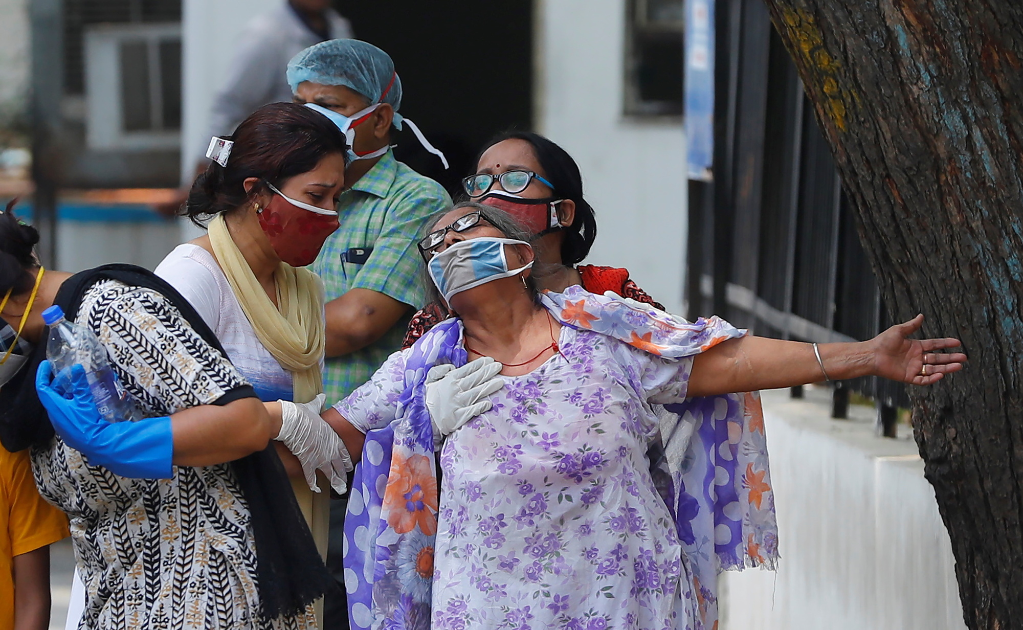 En kvinne sørger over sin døde sønn utenfor et sykehus i New Delhi.