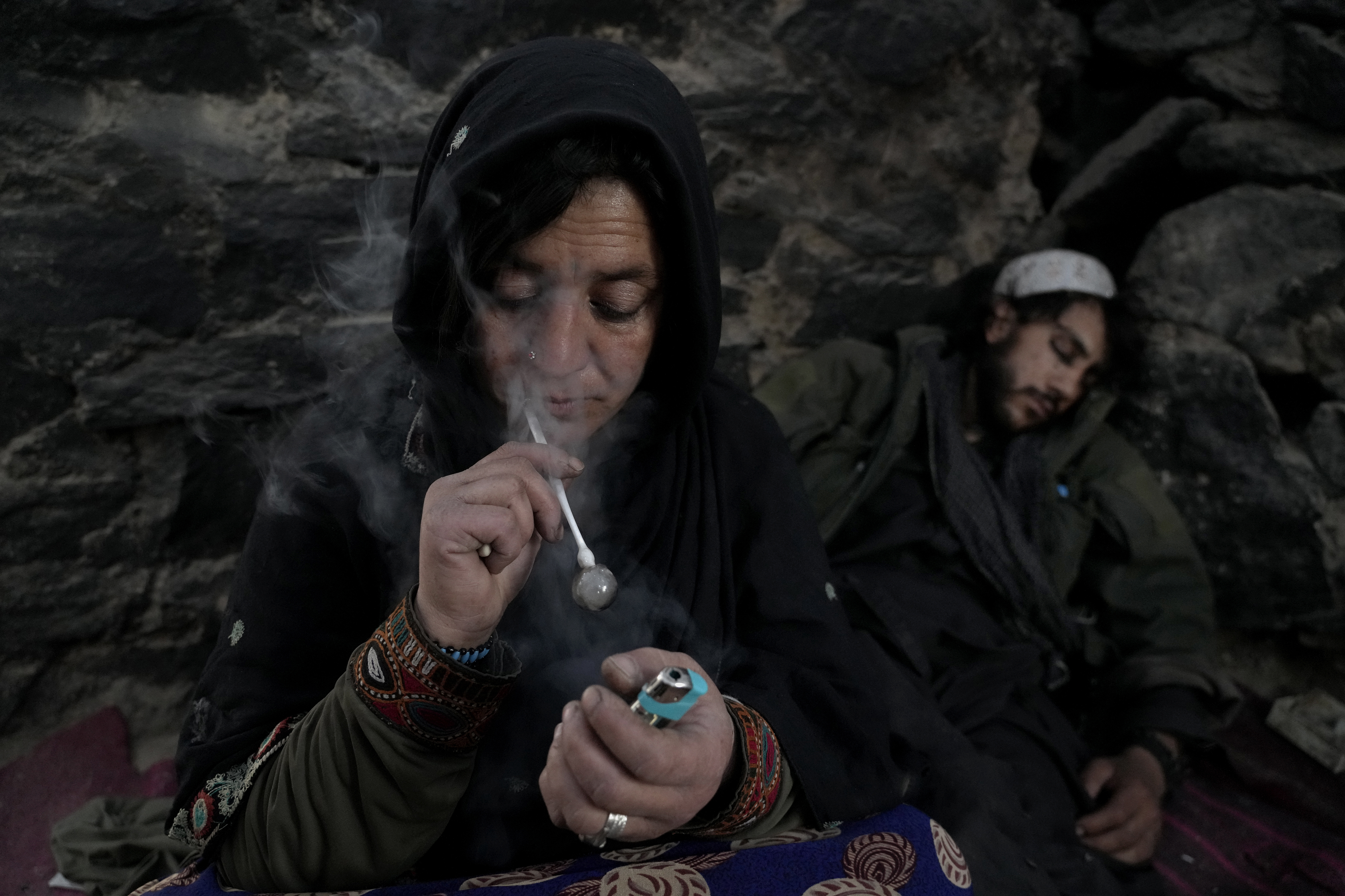 An Afghan drug addict smokes heroin on the edge of a hill in the city of Kabul, Afghanistan,Thursday, June 16, 2022. Drug addiction has long been a problem in Afghanistan, the world’s biggest producer of opium and heroin. The ranks of the addicted have been fueled by persistent poverty and by decades of war that left few families unscarred. (AP Photo/Ebrahim Noroozi)