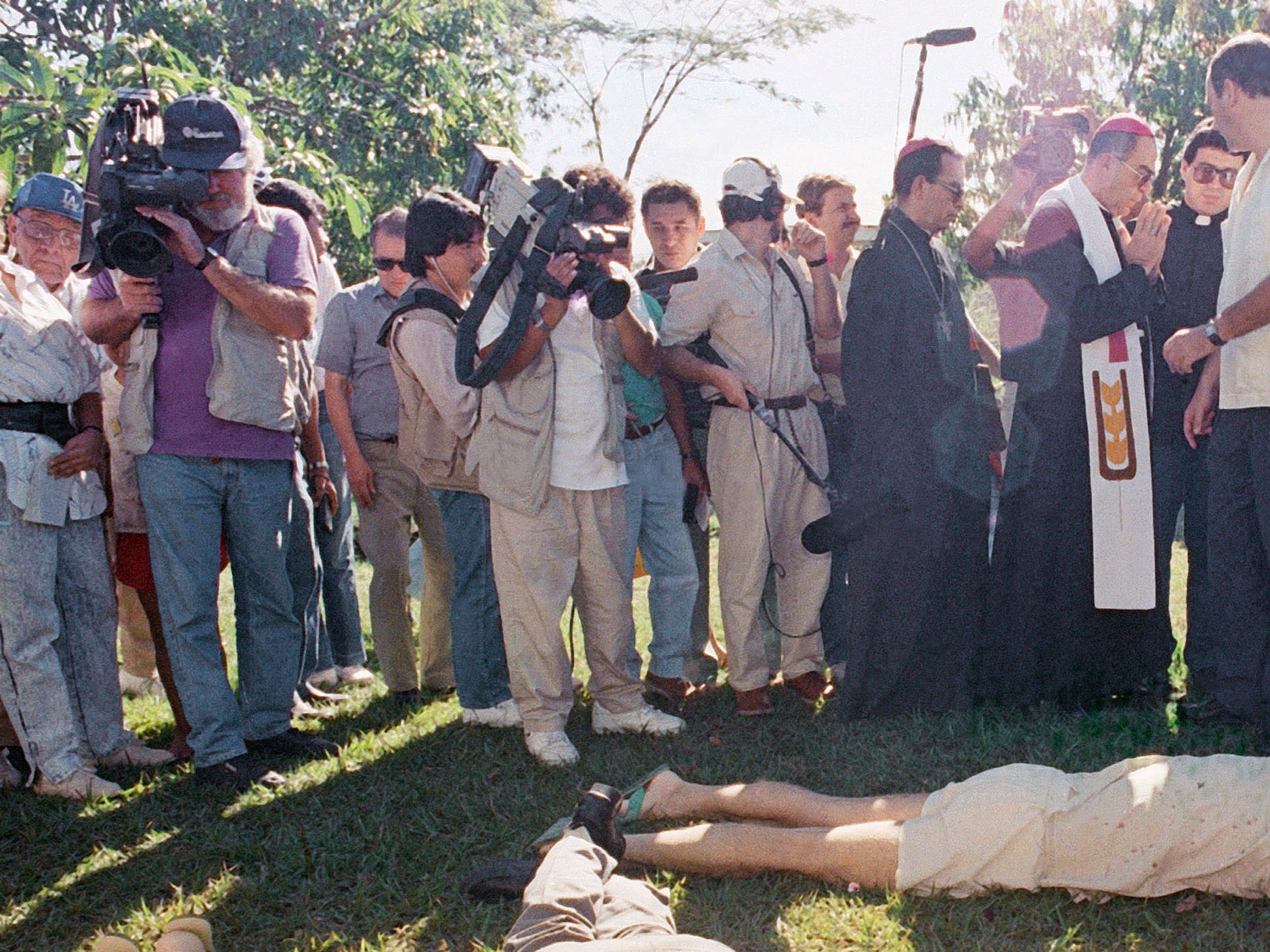 FILE - In this Nov. 16, 1989, file photo, the Archbishop of San Salvador, Mons. Arturo Rivera y Damas and journalists view the bodies of six Jesuit priests murdered in San Salvador. The sentencing of former Salvadoran colonel Inocente Orlando Montano to 133 years in prison by a Spanish court on Friday, Sept. 11, 2020, in relation to the 1989 massacre by an elite comando unit is raising calls once again for El Salvador to investigate and prosecute the masterminds of the massacre. (AP Photo/John Hopper, File)