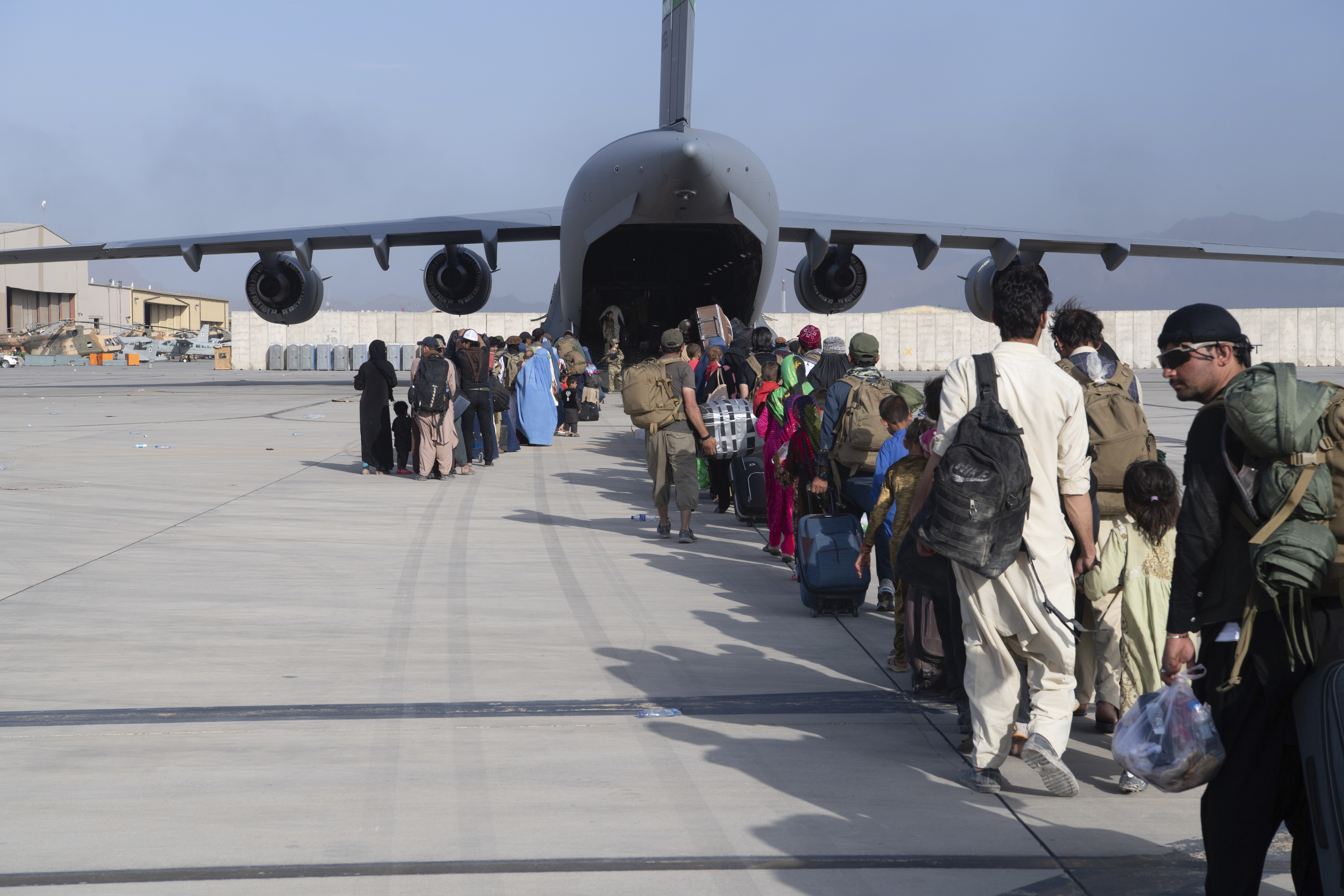 Afghanere i kø for å gå om bord i et amerikansk militærfly. Taliban lover ifølge USA å la amerikanere og afghanere i faresonen å forlate Afghanistan også etter 31. august. Foto: AP / NTB