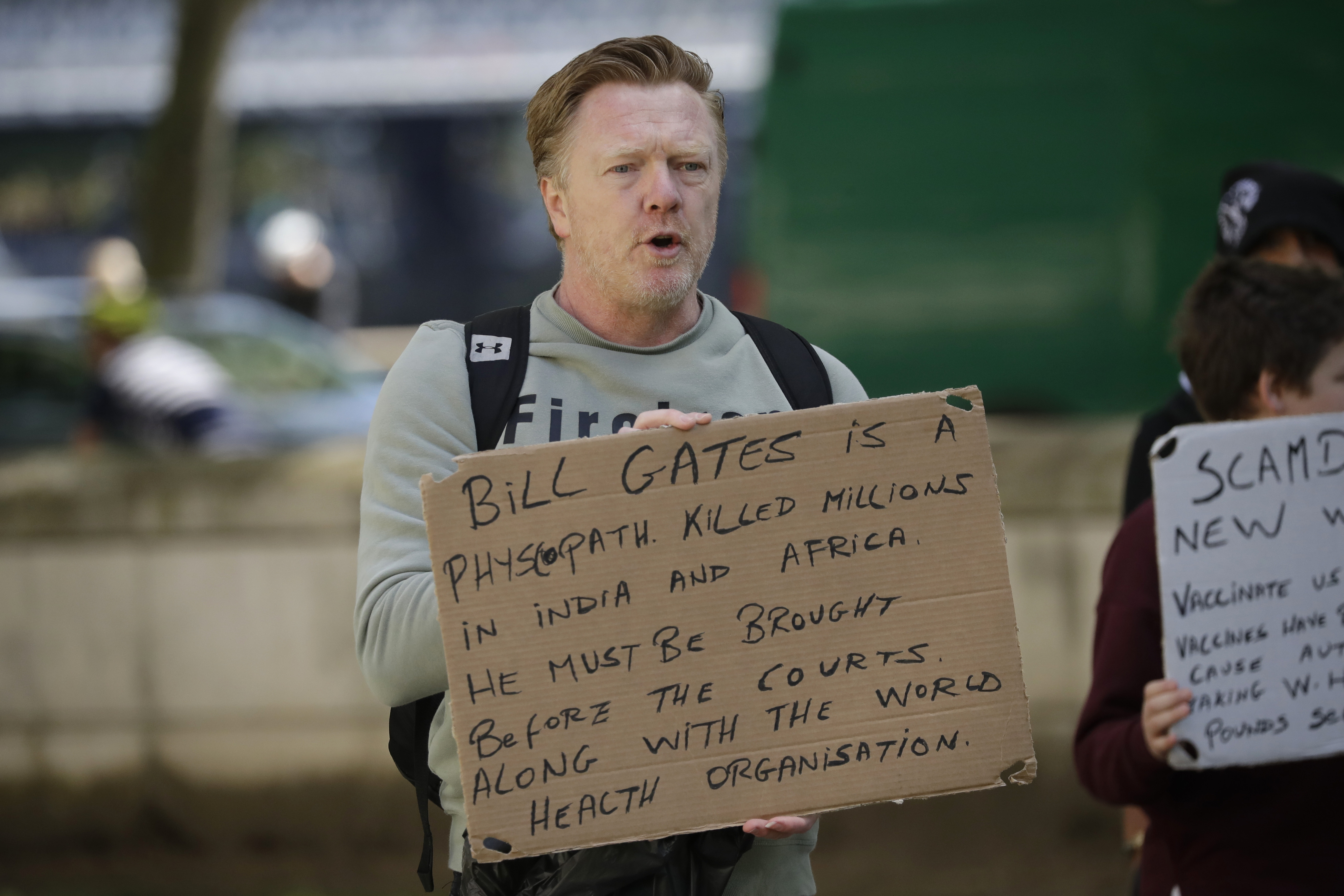 A man holds up an anti Bill Gates placard at a coronavirus anti-lockdown, anti-vaccine, anti-5G and pro-freedom protest near Scotland Yard, the headquarters of London's Metropolitan Police Service, in London, Saturday, May 2, 2020. Civil liberties have been limited with self isolation and exercising social distancing imposed to limit the spread of the highly contagious COVID-19 coronavirus. (AP Photo/Matt Dunham)