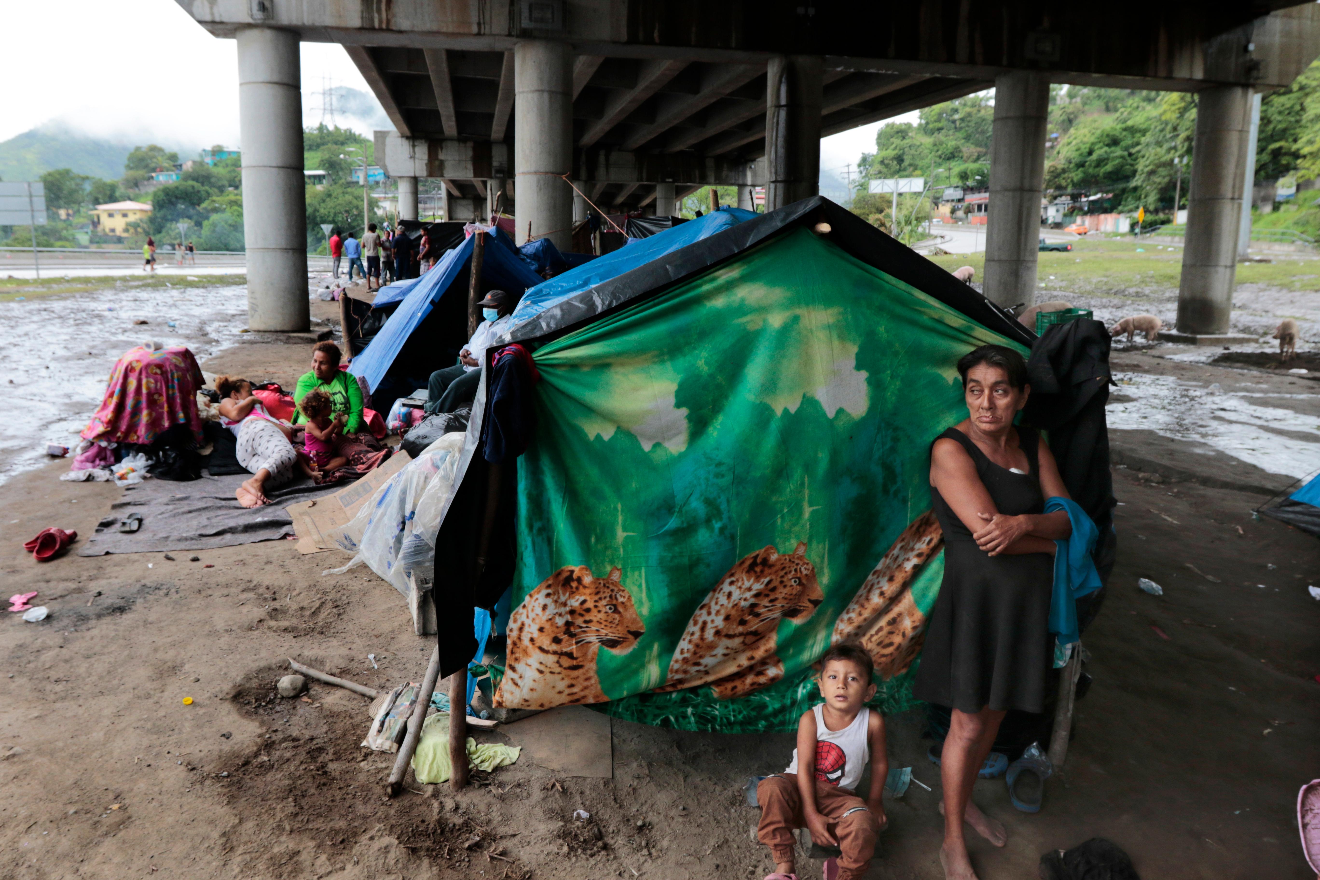 Hurricane victims take refuge under a bridge in San Pedro Sula, Honduras, Saturday, Nov. 21, 2020. Shelters for people whose homes were flooded or damaged by hurricanes Eta and Iota in Honduras are now so crowded that thousands of victims have taken refuge under highway overpasses or bridges. The Red Cross estimates that about 4.2 million people were affected by the back-to-back hurricanes in November in Honduras, Nicaragua and Guatemala. (AP Photo/Delmer Martinez)